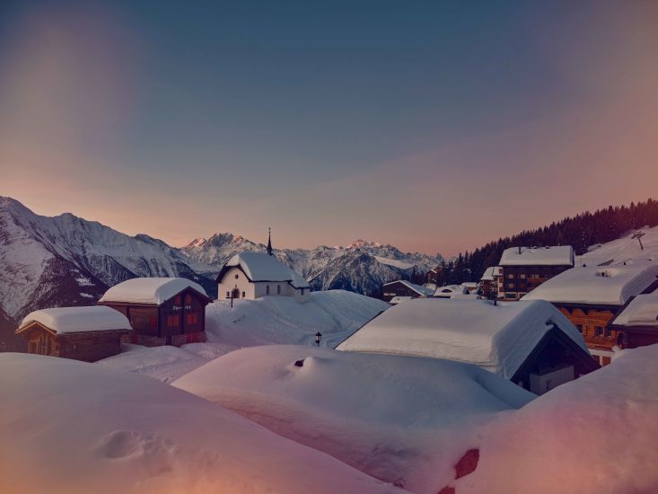 Schneebedeckte Dächer in der Aletsch Arena, Winter im Wallis, Schweiz