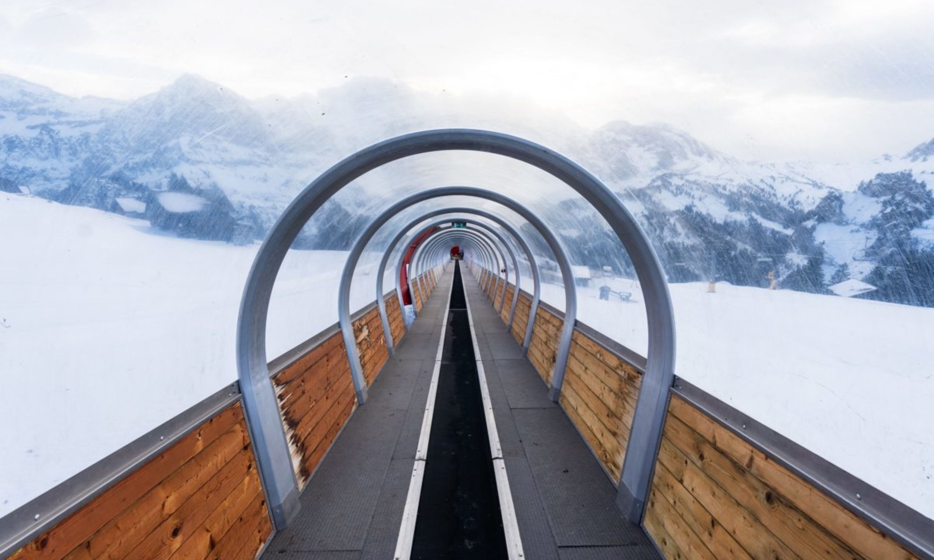 Vue à travers le tapis couvert à Champéry, dans le domaine skiable des Portes du Soleil, avec des montagnes enneigées en arrière-plan.