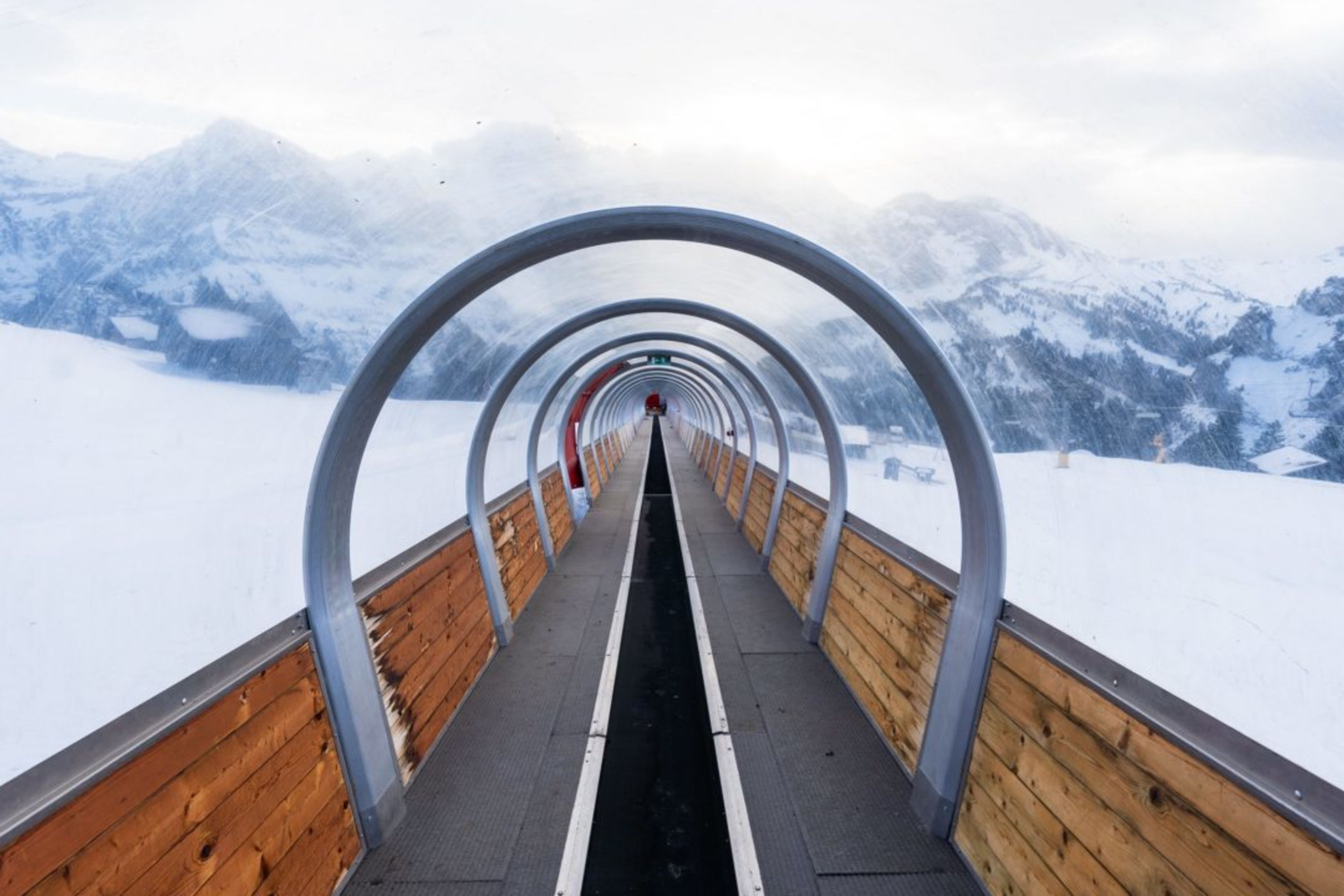 Vue à travers le tapis couvert à Champéry, dans le domaine skiable des Portes du Soleil, avec des montagnes enneigées en arrière-plan.