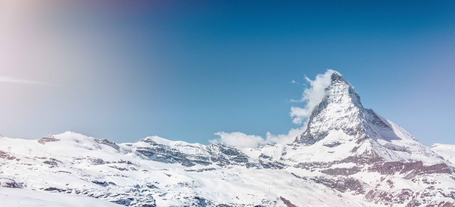 Herrlicher Blick auf das schneebedeckte Matterhorn in Zermatt im Winter mit ein paar Wolken an der Spitze des Berges. Wallis, Schweiz.