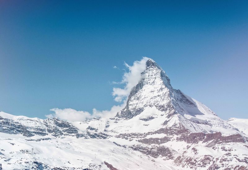 Magnificent view of the snow-covered Matterhorn in Zermatt in winter with a few clouds at the top of the mountain. Valais, Switzerland.
