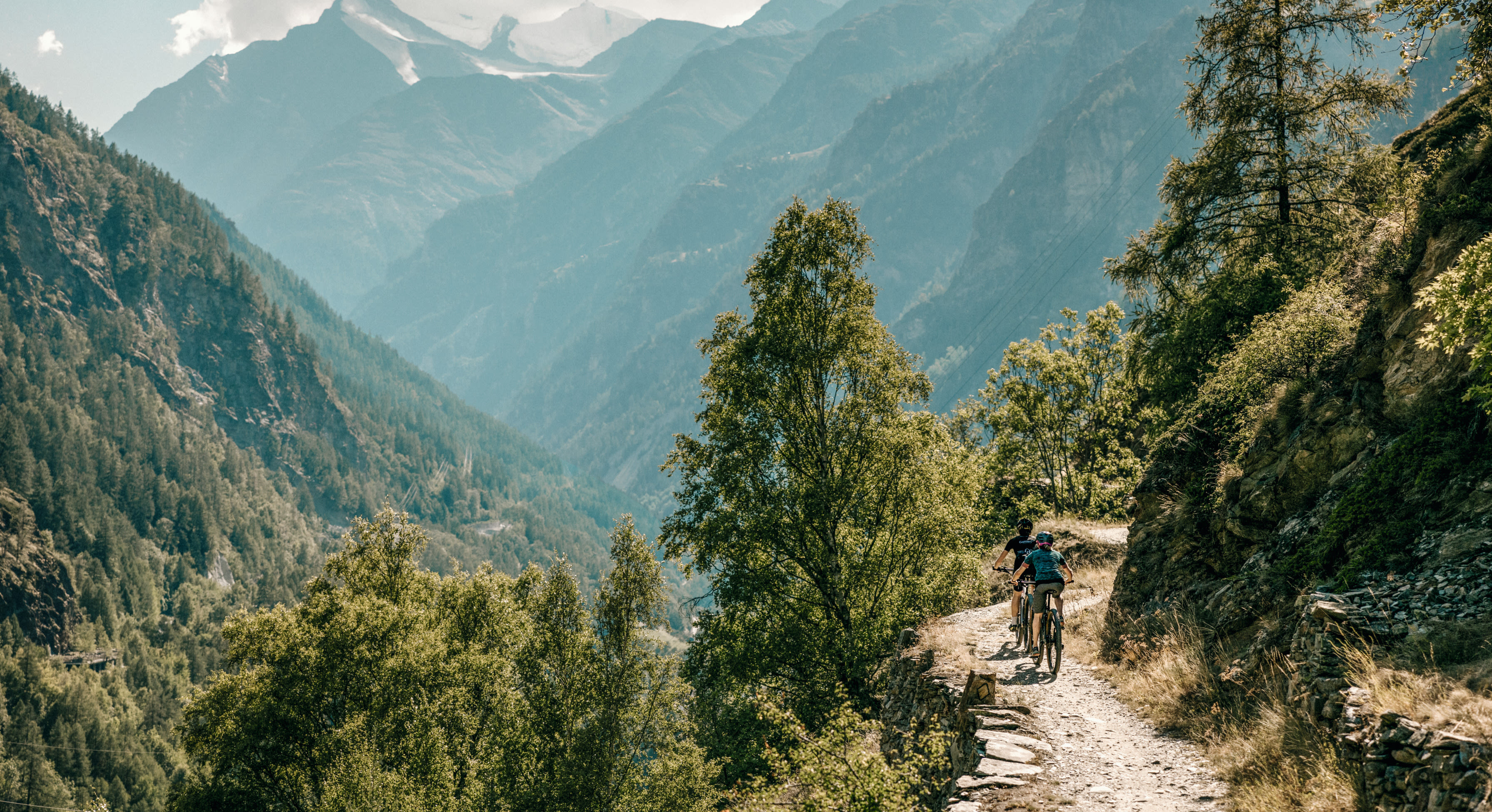 Des cyclistes faisant du VTT en montagne sur un chemin balisé. Valais, Suisse.