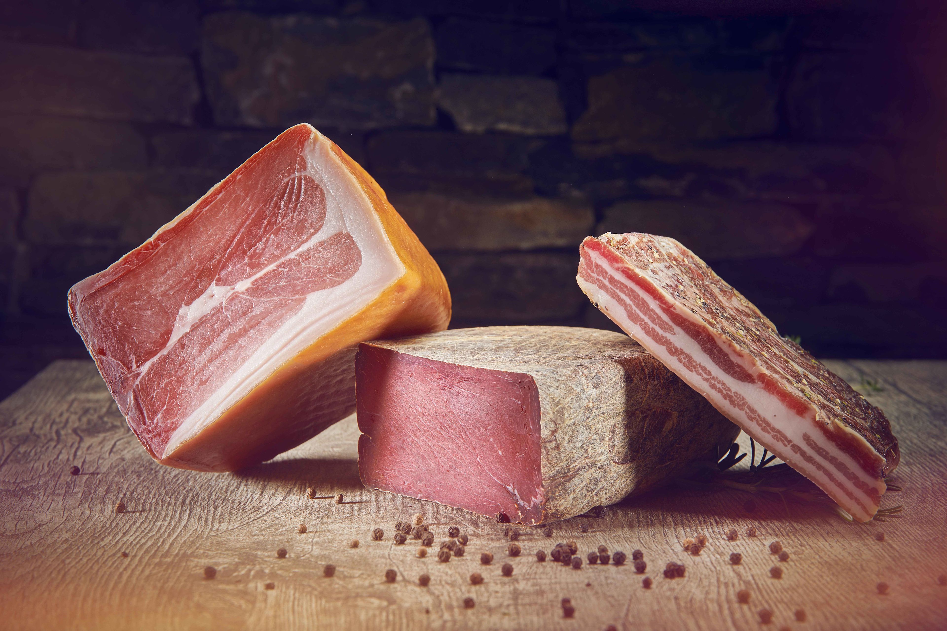 Rohschinken, Trockenfleisch und trockener Speck auf einem Holztisch, Valais Wallis, Schweiz Suisse