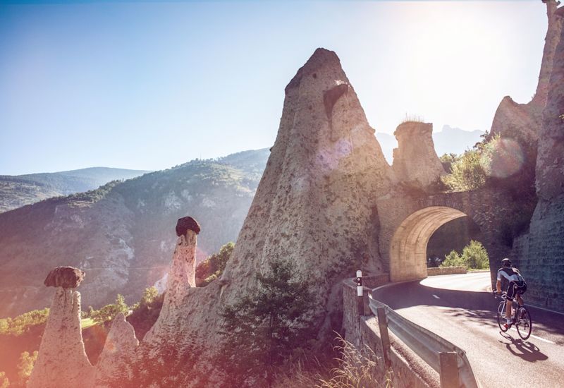 Au fil des vallées valaisannes en vélo. Le cycliste roule dessous des pyramides d'Euseigne en Valais Wallis Schweiz Switzerland Suisse