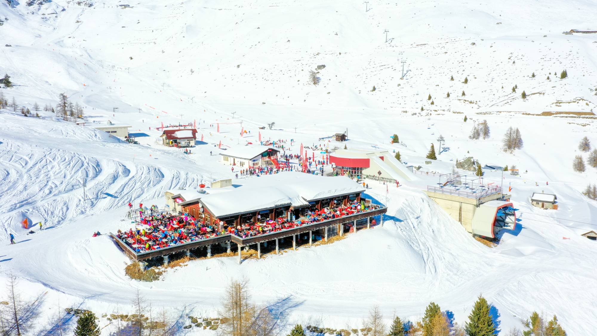 Skifahrer und Gäste auf der Terrasse der Station Bendolla in Grimentz