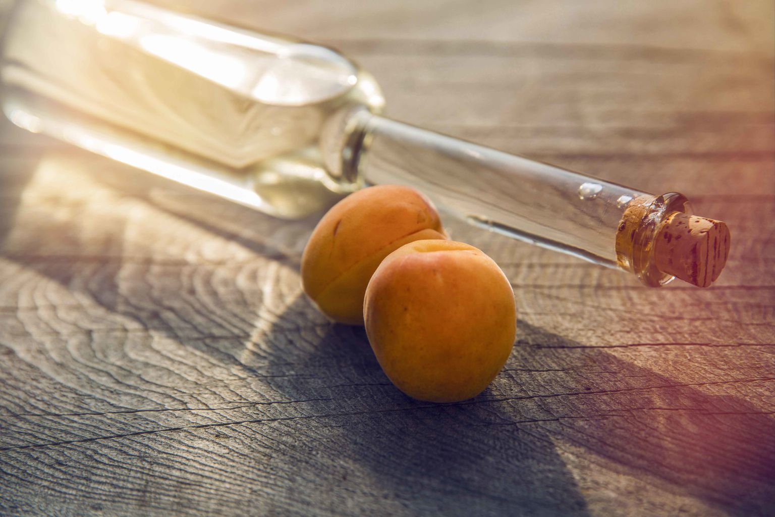 Two apricots next to a glass bottle, Valais, Switzerland