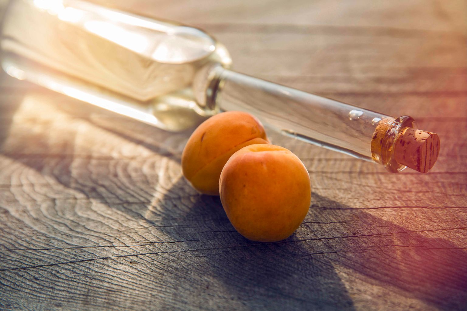 Deux abricots à côté d'une bouteille en verre, Valais, Suisse