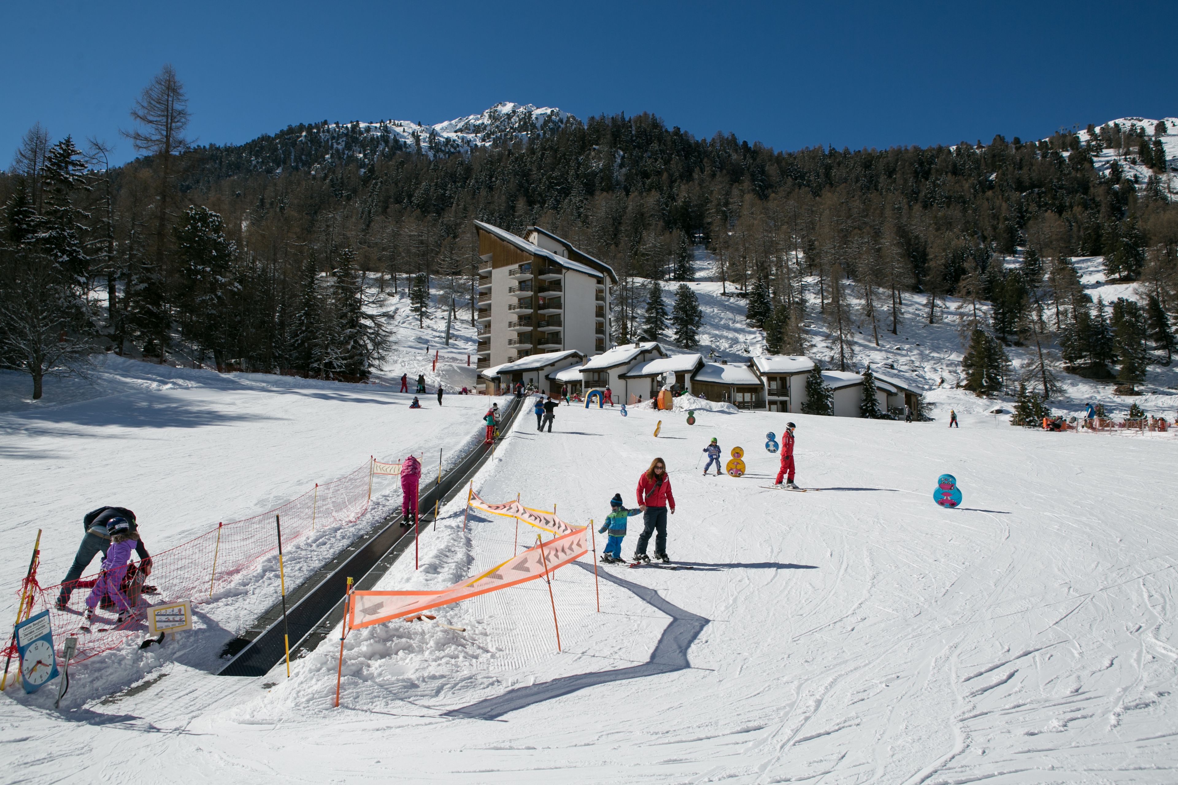 Children learning to ski in the Siviez snow garden with magic carpet and play features