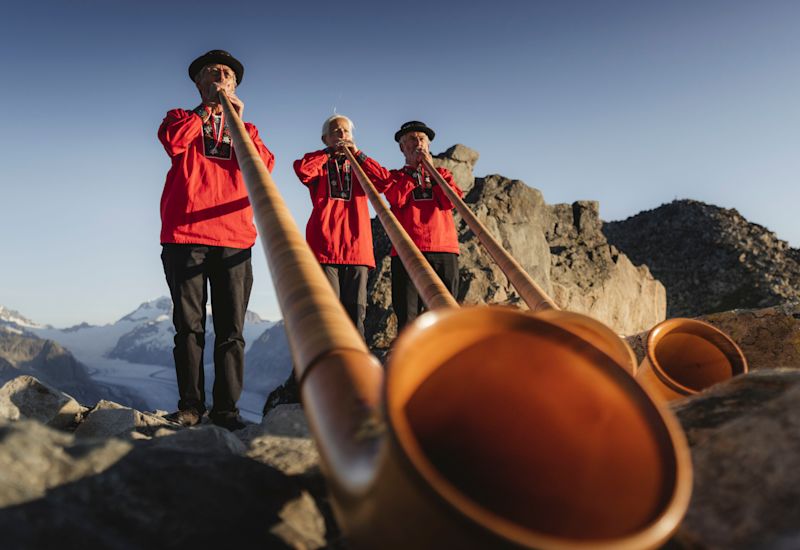 Three men playing Corps des Alpes, Eggishorn, Aletsch arena, Valais, Switzerland.