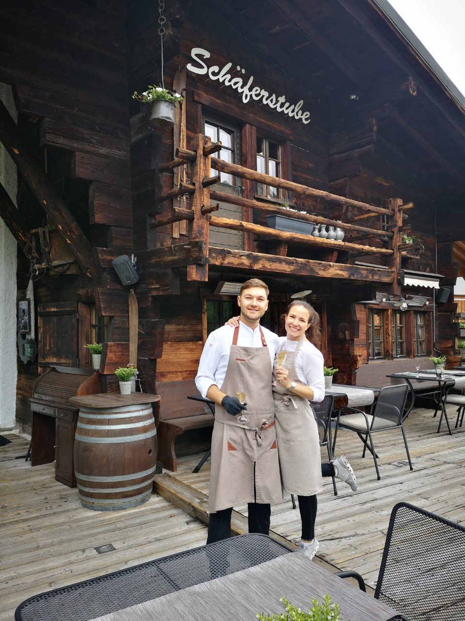 Le restaurant Schäferstube à Saas-Fee, Valais, avec sa façade en bois traditionnelle et ses hôtes sur la terrasse ensoleillée