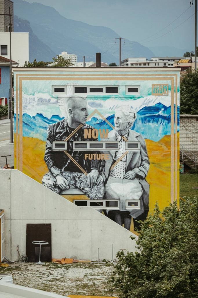 «Now Future» von Jasm One ziert die Fassade des Kultur- und Freizeitzentrums Aslec in Sierre, direkt am Bahnhof, Wallis, Schweiz
