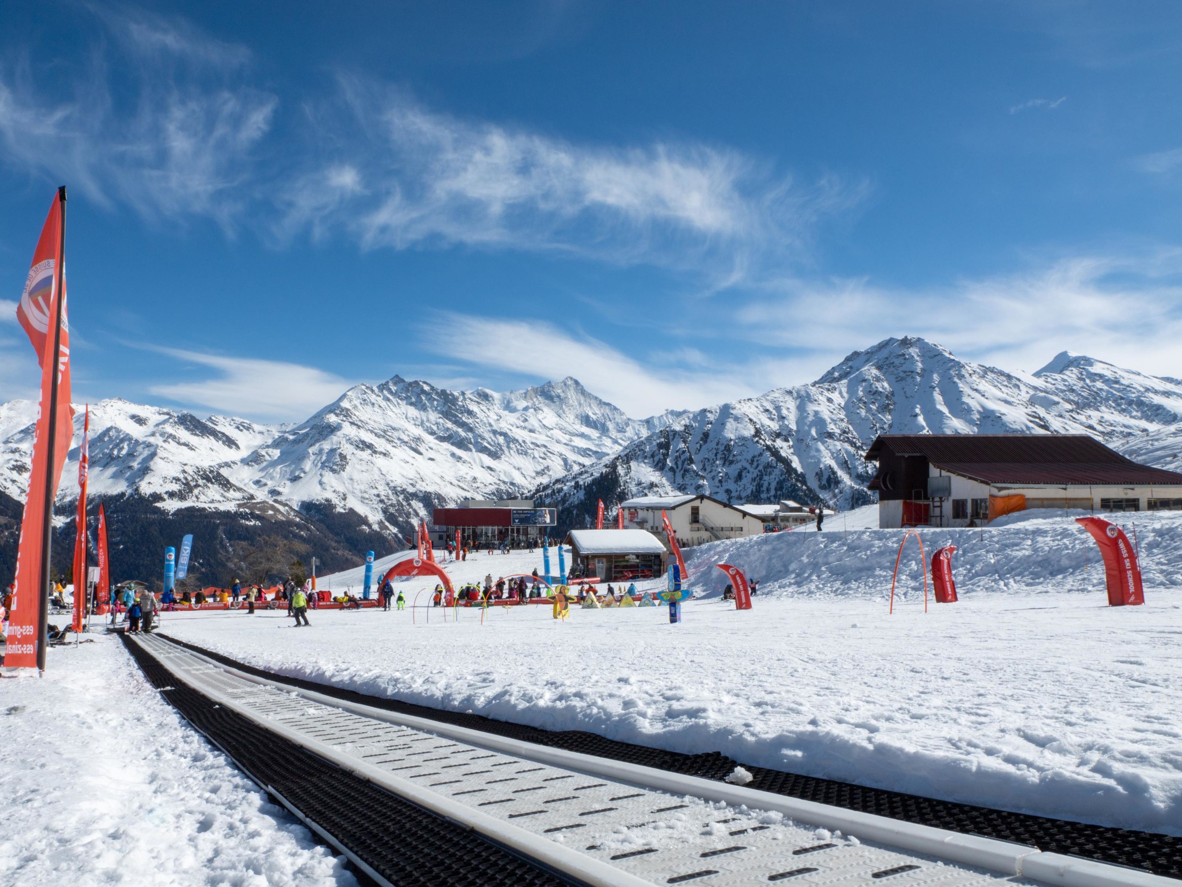 Kinder lernen das Skifahren im Minigliss-Gelände in Grimentz vor alpiner Kulisse