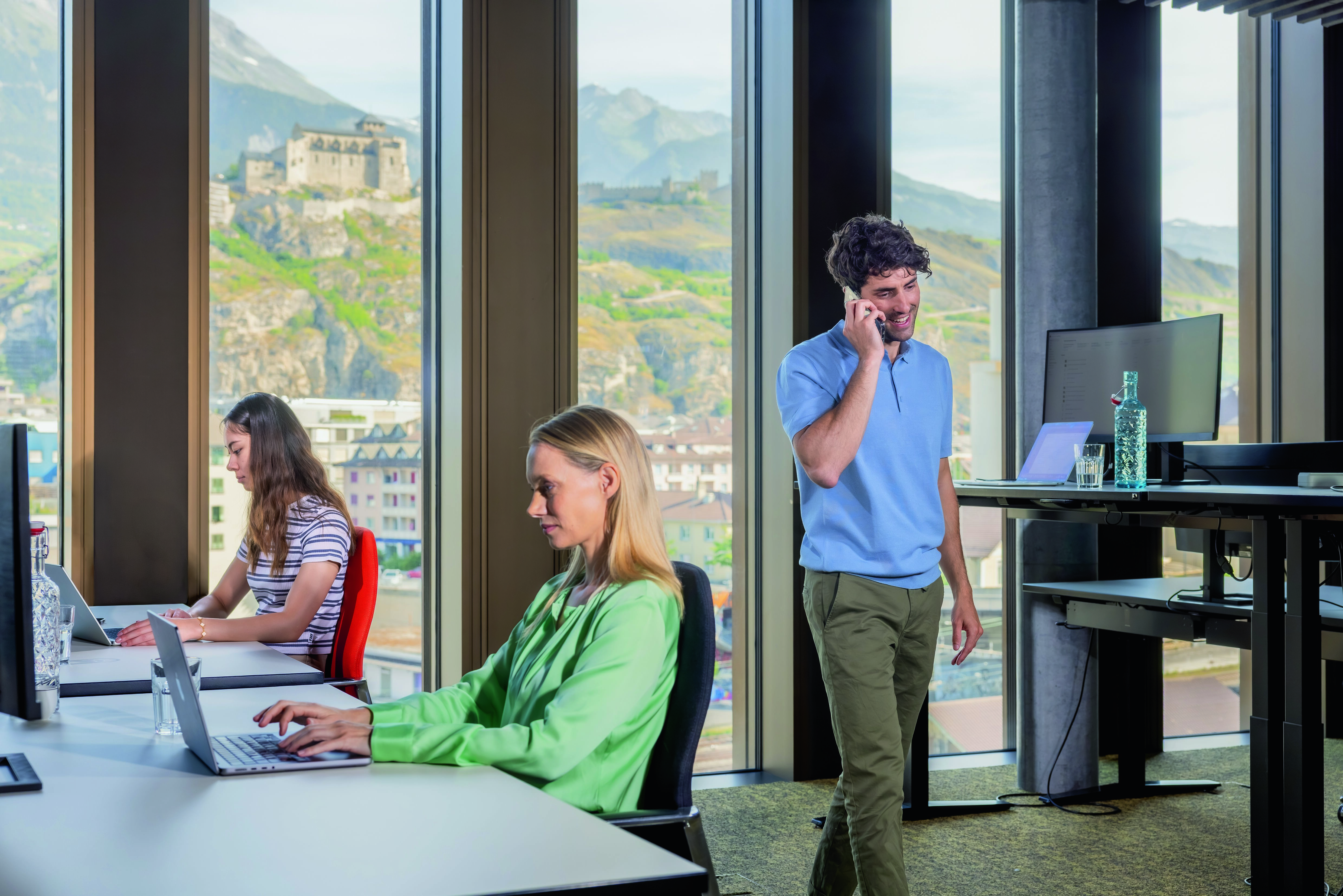 Collaborateurs travaillant dans un bureau avec vue sur Sion, Valais, Suisse