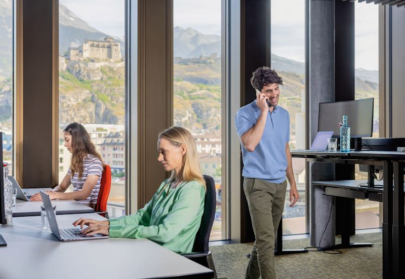 Colleagues working in an office with a view over Sion, Valais, Switzerland