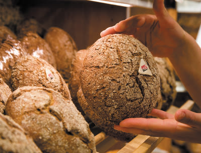 The baker stores freshly baked rye bread on the shelves Valais Wallis, Schweiz Suisse