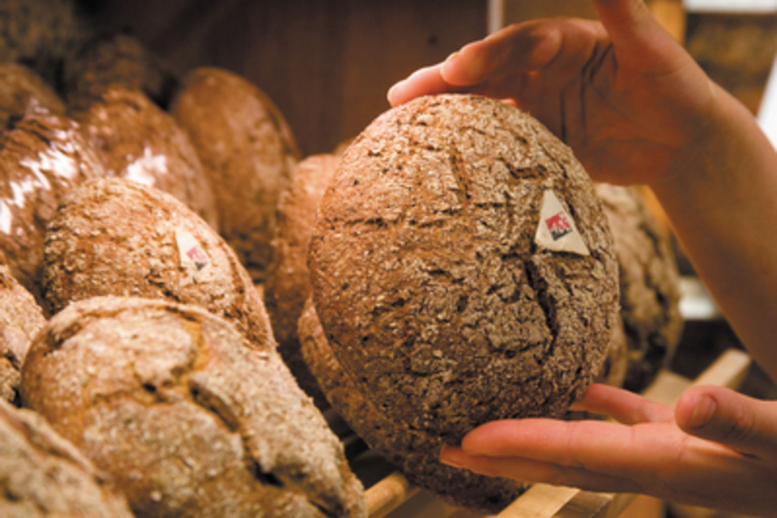 The baker stores freshly baked rye bread on the shelves Valais Wallis, Schweiz Suisse