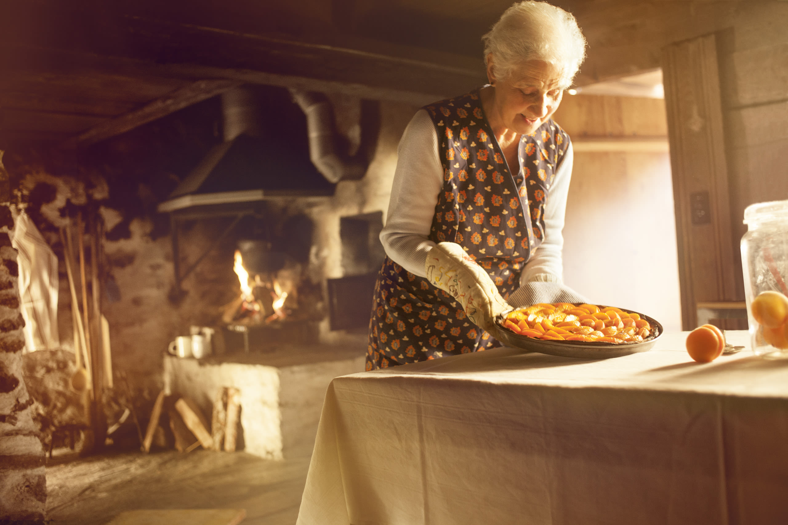 Frau nimmt Aprikosenkuchen aus dem Ofen, Walliser Aprikosen