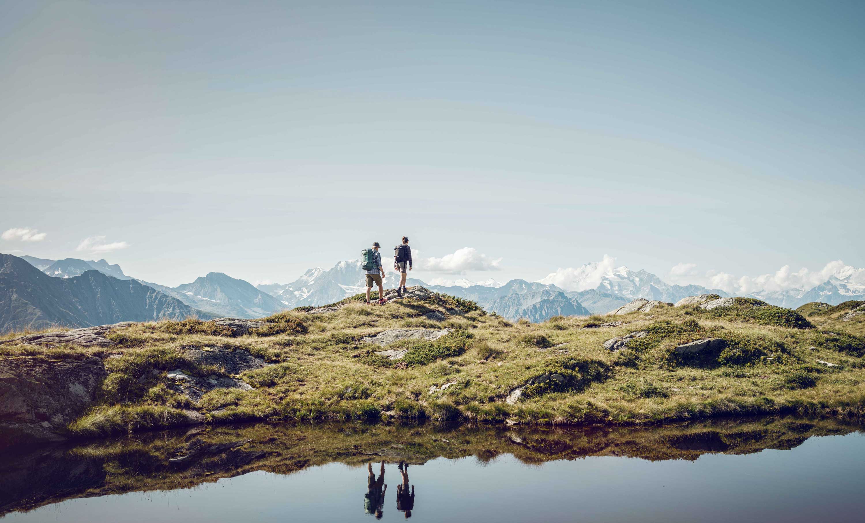 Deux randonneurs marchent à côté d'un lac dans la Région d'Aletsch. Valais, Suisse