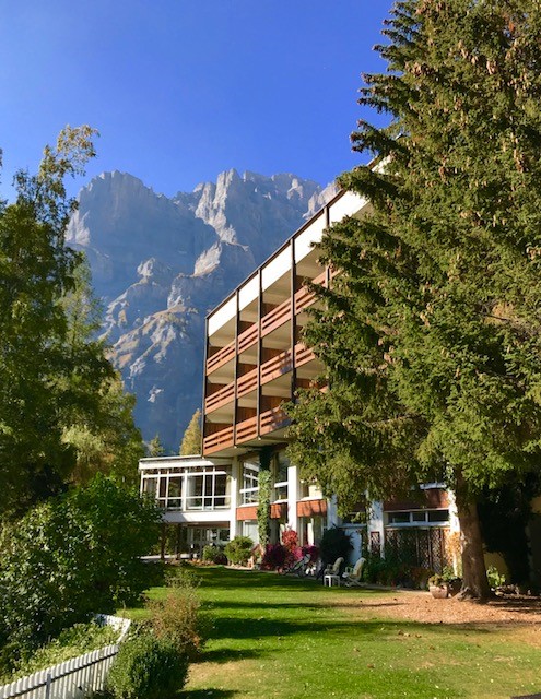 Hotel Regina Terme in Leukerbad, umgeben von Natur und Bergen, mit Blick auf die Felsen
