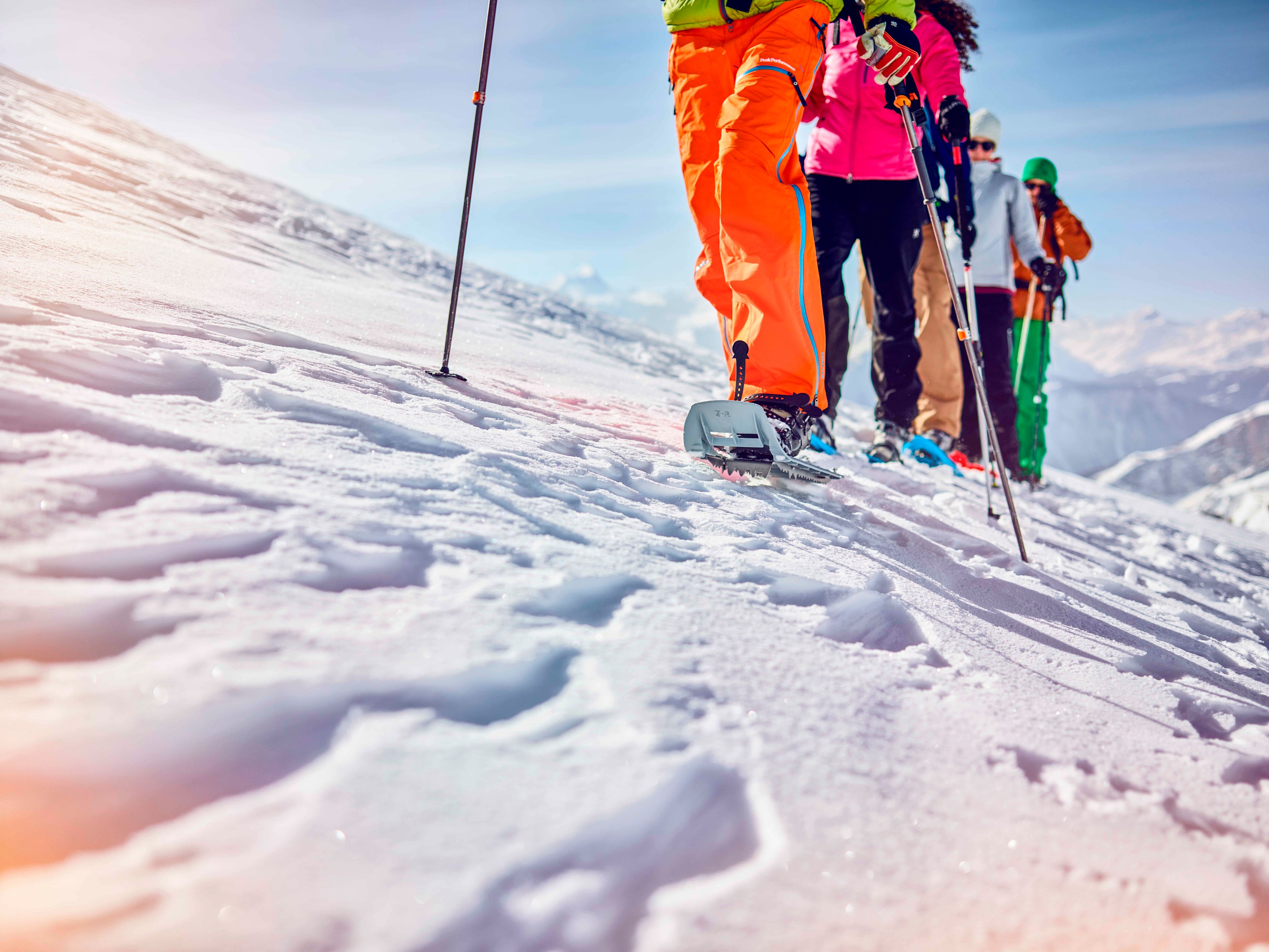 Four winter hikers in Leukerbad on snowshoes, Valais, Switzerland