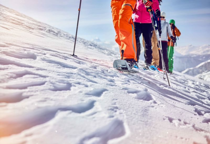 Quatre randonneurs hivernaux à Loèche-les-Bains en raquettes à neige, Valais, Suisse