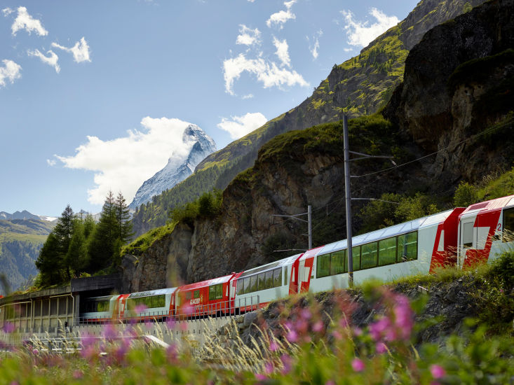 Le train Glacier Express vient de partir de Zermatt. Nous pouvons voir le Cervin en arrière plan. Valais. Suisse