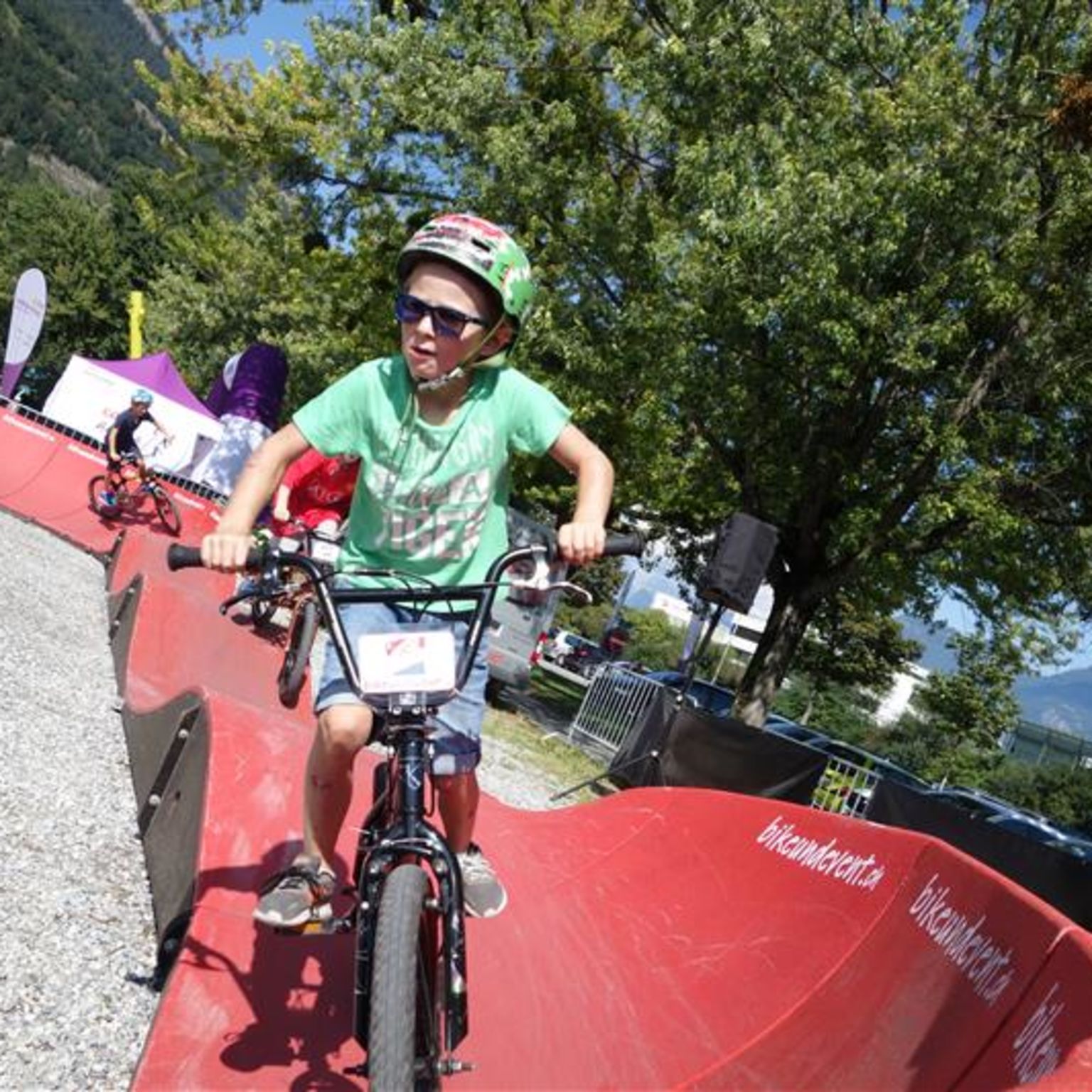 Kind fährt mit einem Fahrrad auf dem Pumptrack von Reckingen im Goms