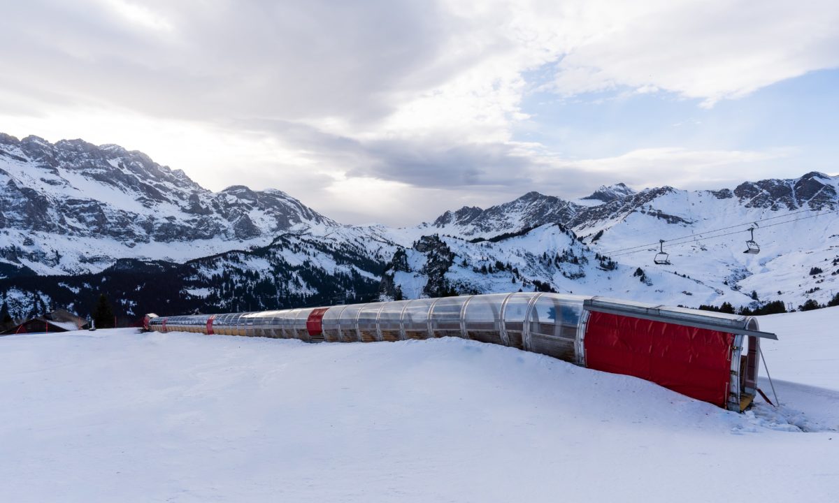 Vue extérieure du tapis couvert à Champéry, dans le domaine skiable des Portes du Soleil, avec un paysage montagneux spectaculaire en arrière-plan.