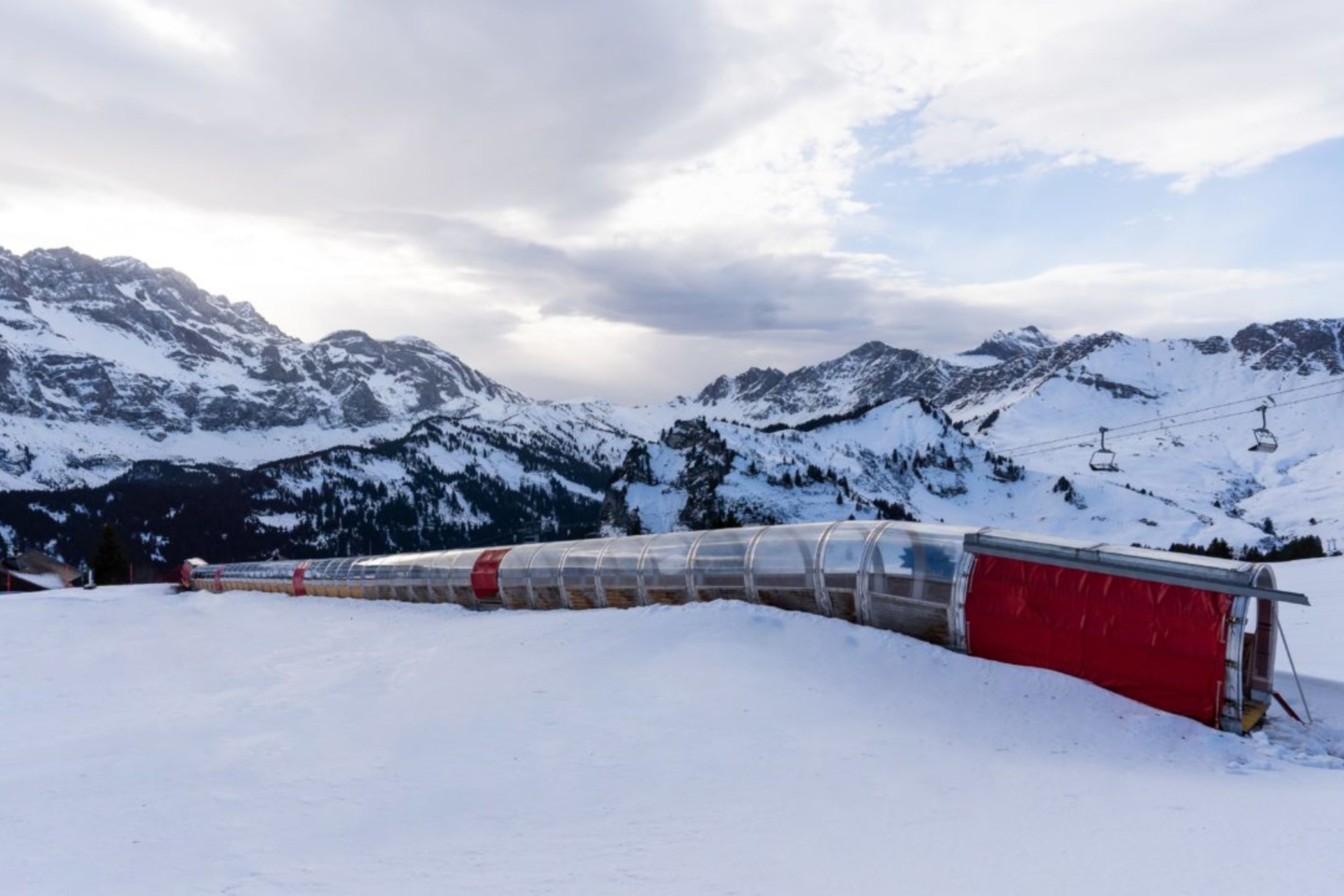 Vue extérieure du tapis couvert à Champéry, dans le domaine skiable des Portes du Soleil, avec un paysage montagneux spectaculaire en arrière-plan.
