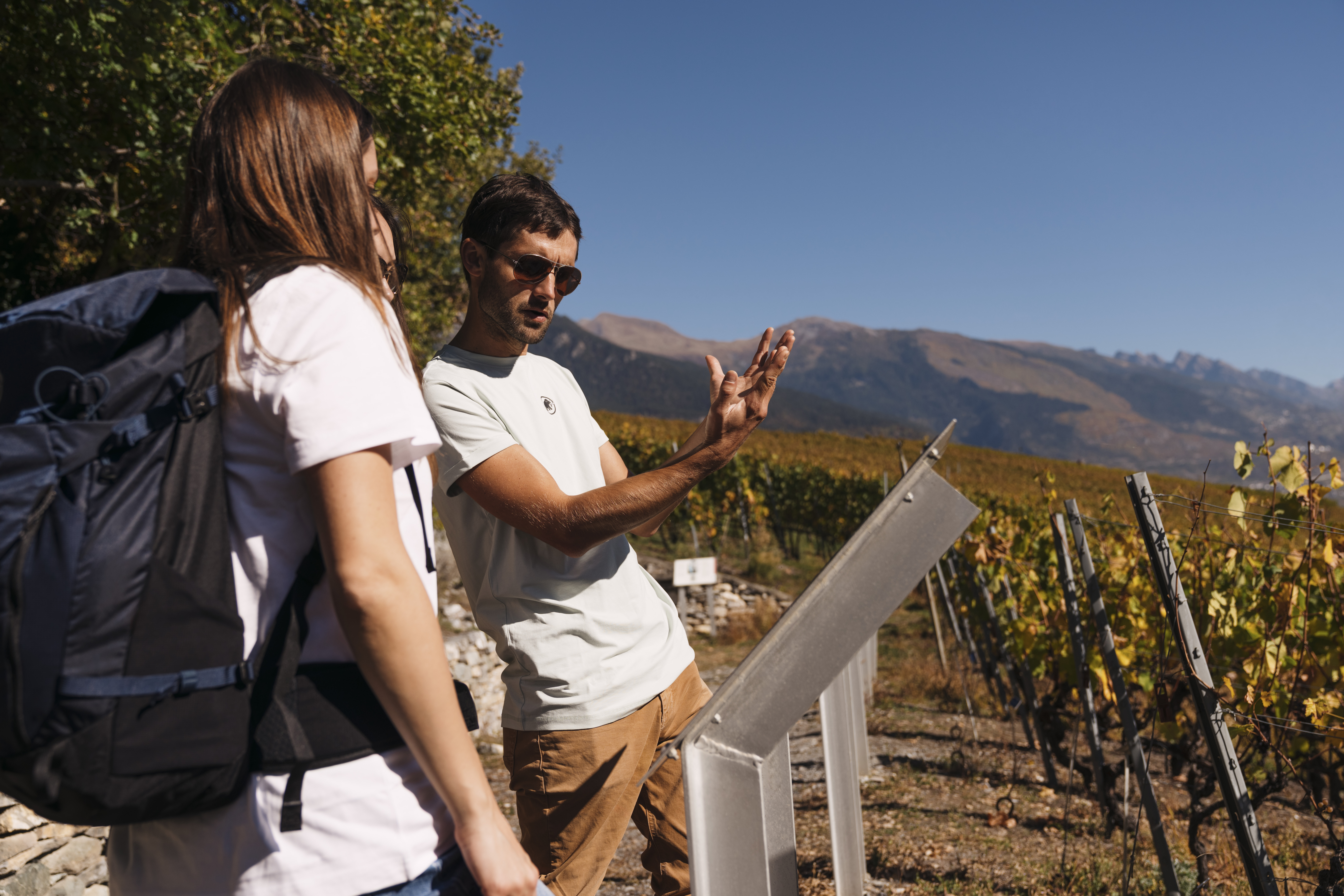 Deux randonneurs découvrent l’un des 80 panneaux consacrés à l’histoire de la vigne dans les vignobles, Valais, Suisse