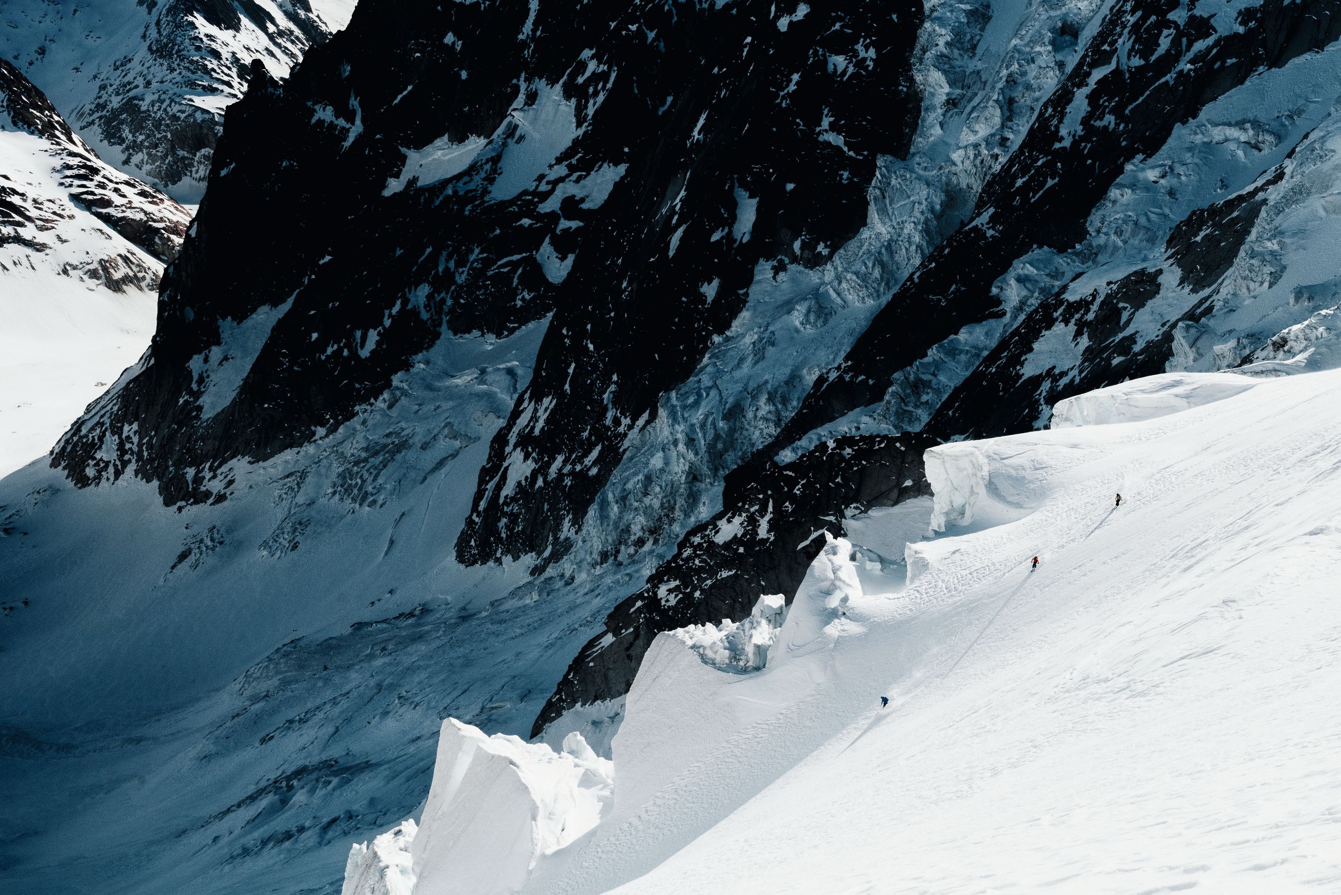 Skifahrer fahren im Lötschental die Hänge eines Gletschers hinunter.