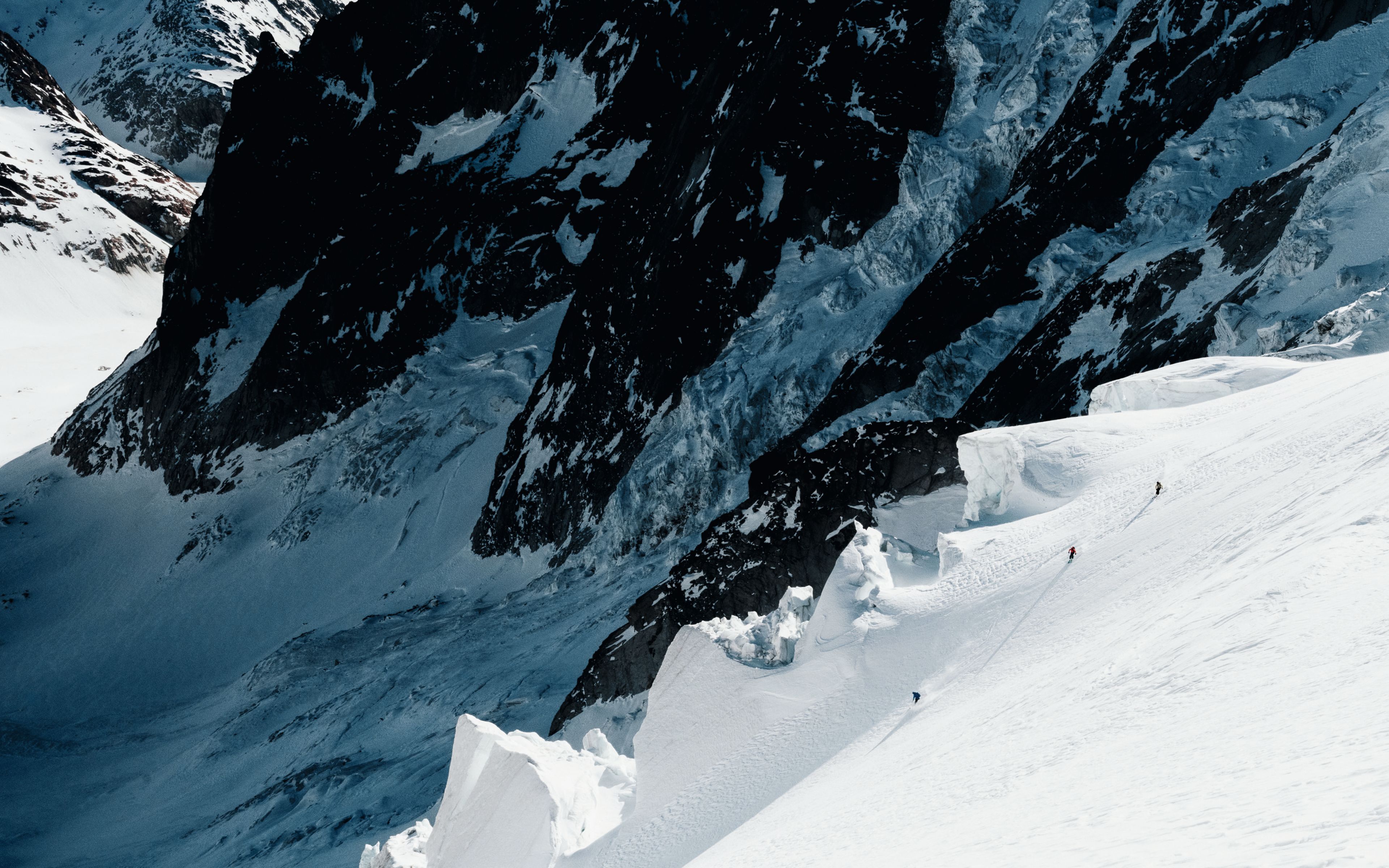 Skifahrer fahren im Lötschental die Hänge eines Gletschers hinunter.