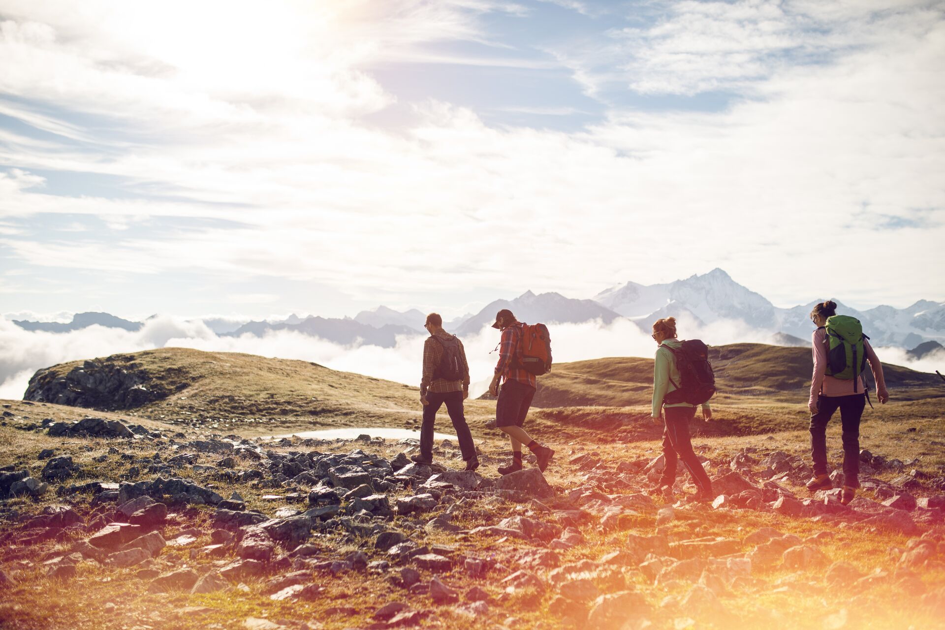 Gruppe von Wanderern unterwegs im Vallon de Réchy mit Blick auf die Walliser Alpen