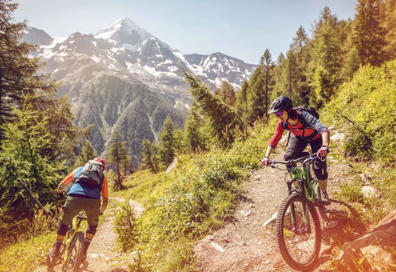 Der Schüler folgt seinem Guide auf einer Mountainbike-Tour das Lötschental hinunter., Valais Wallis Schweiz Suisse