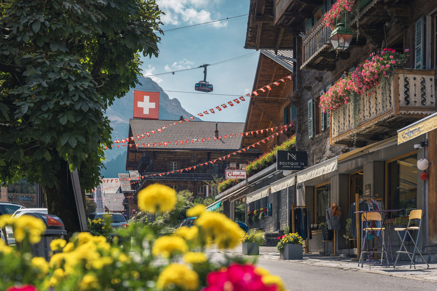 Das wunderschöne Dorf Champery mit seinen Blumen, Chalets und im Hintergrund die Skilifte. Wallis, Schweiz.