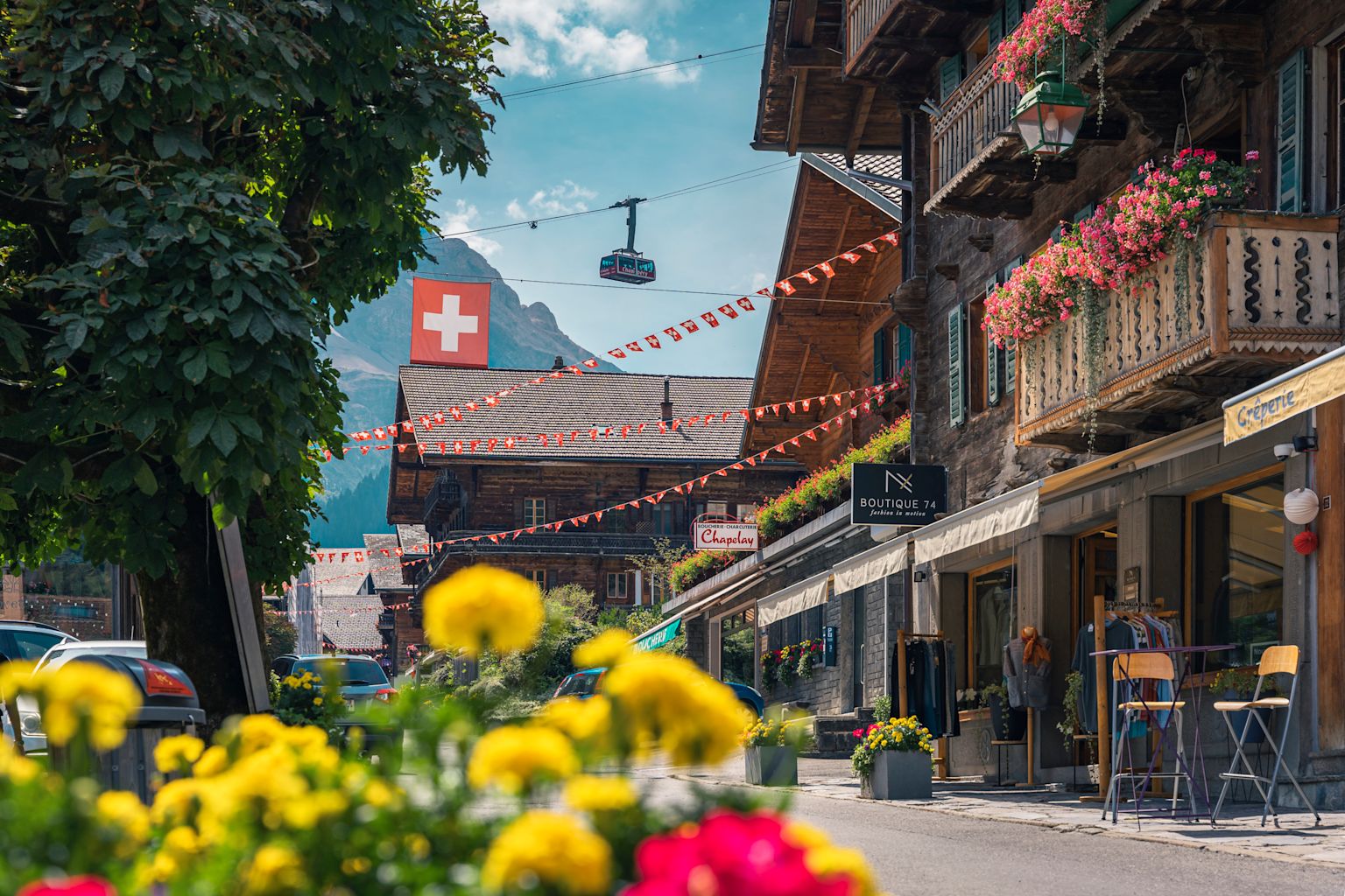 Le magnifique village de Champery avec ses fleurs, ses chalets et en arrière plan ses remontées mécaniques. Valais, Suisse.