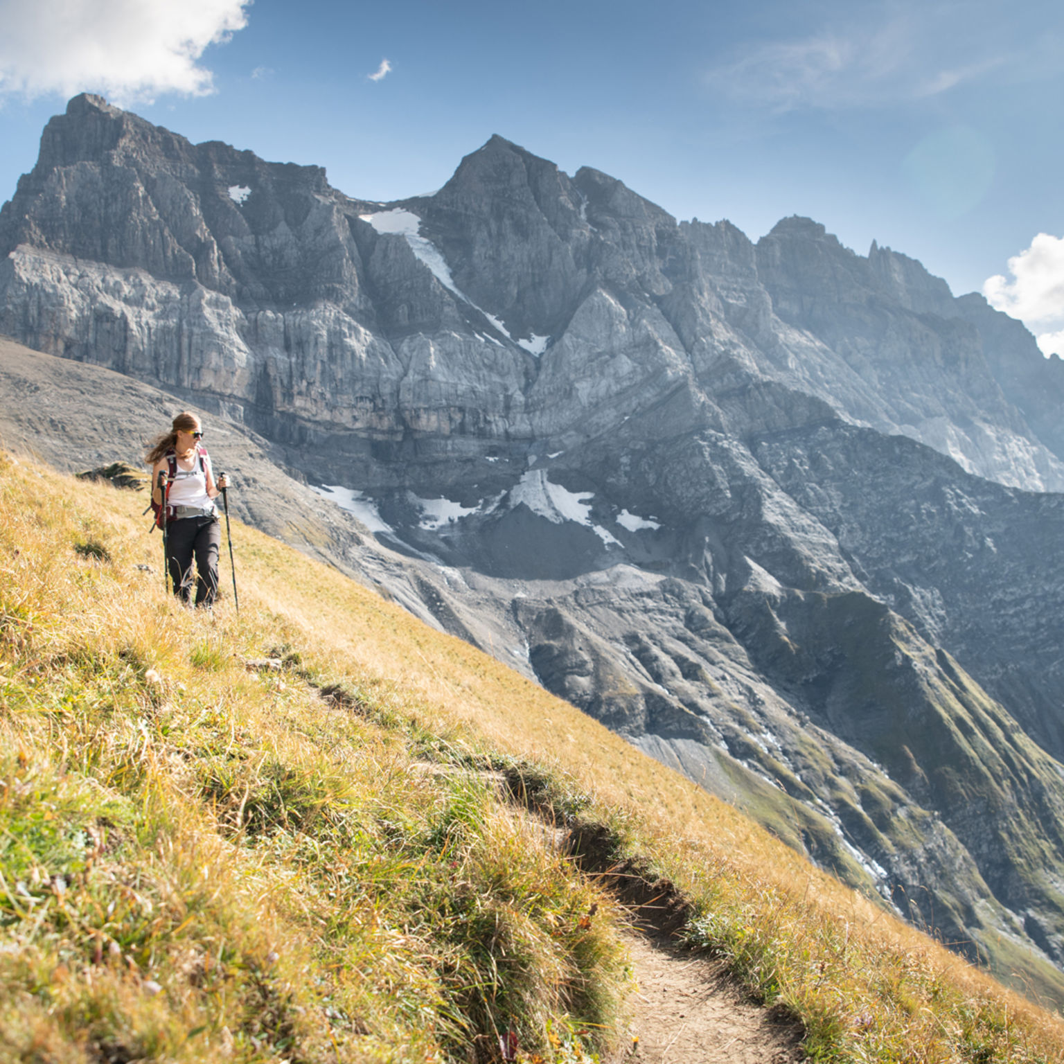 A lady is hiking with the Dents du Midi in the background. Valais. Switzerland