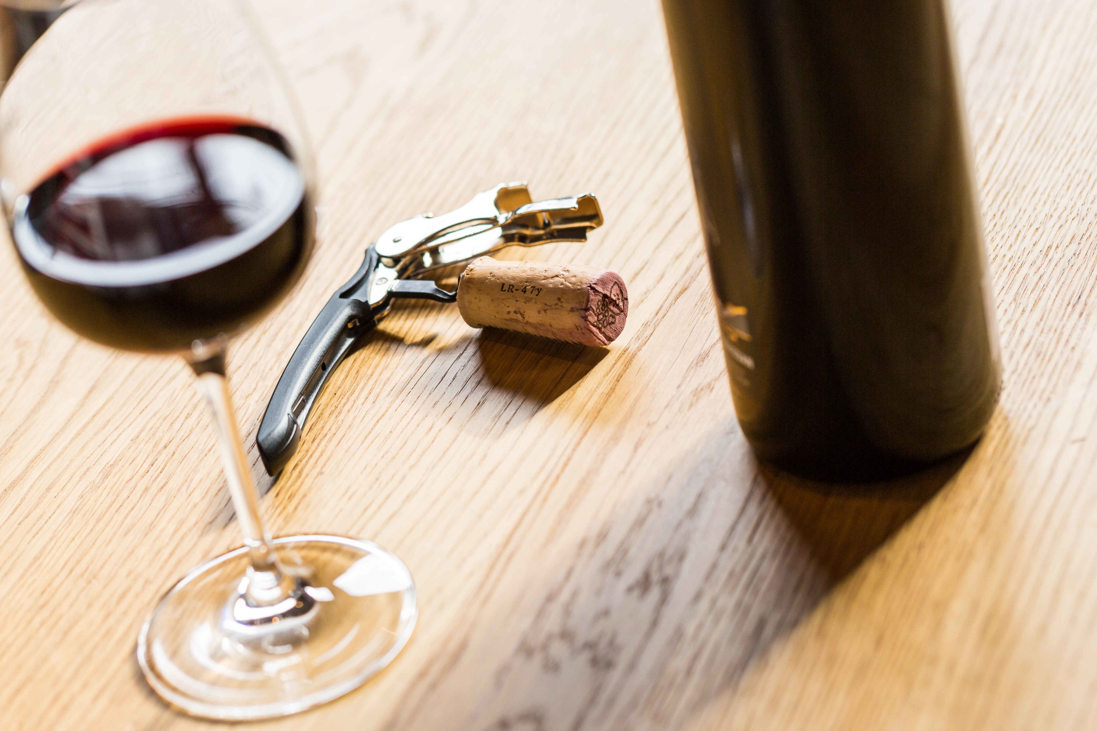 A bottle of Valaisan wine with its corkscrew and a wine glass, Valais Switzerland