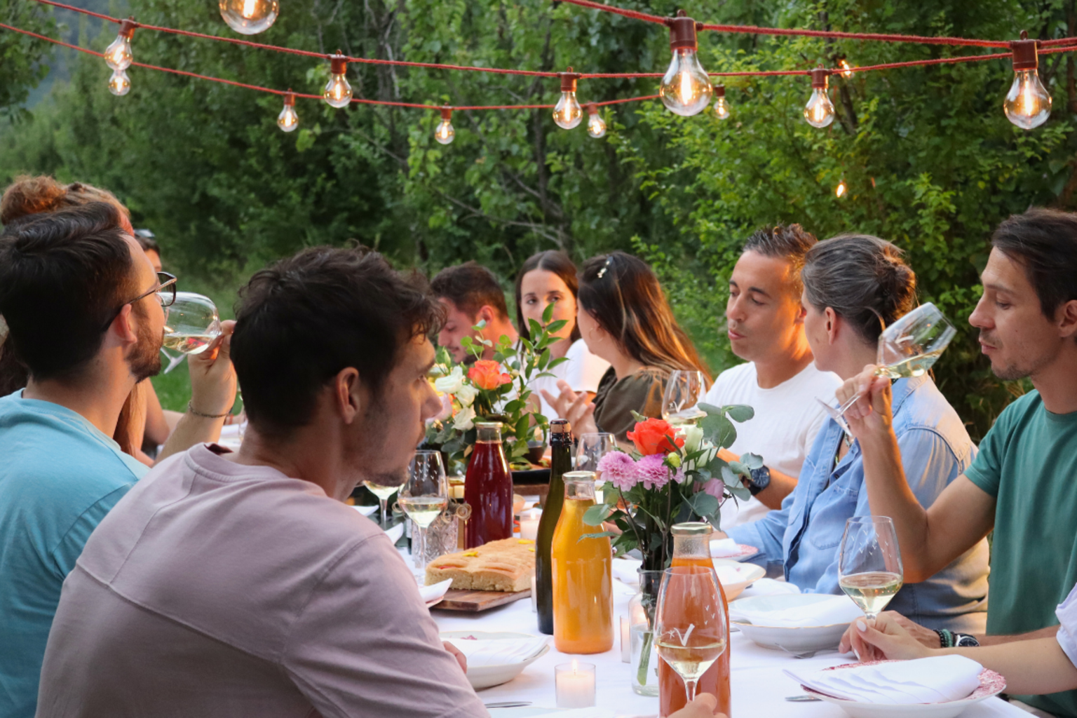 A group of colleagues enjoy a meal around an outdoor table in the Valais.