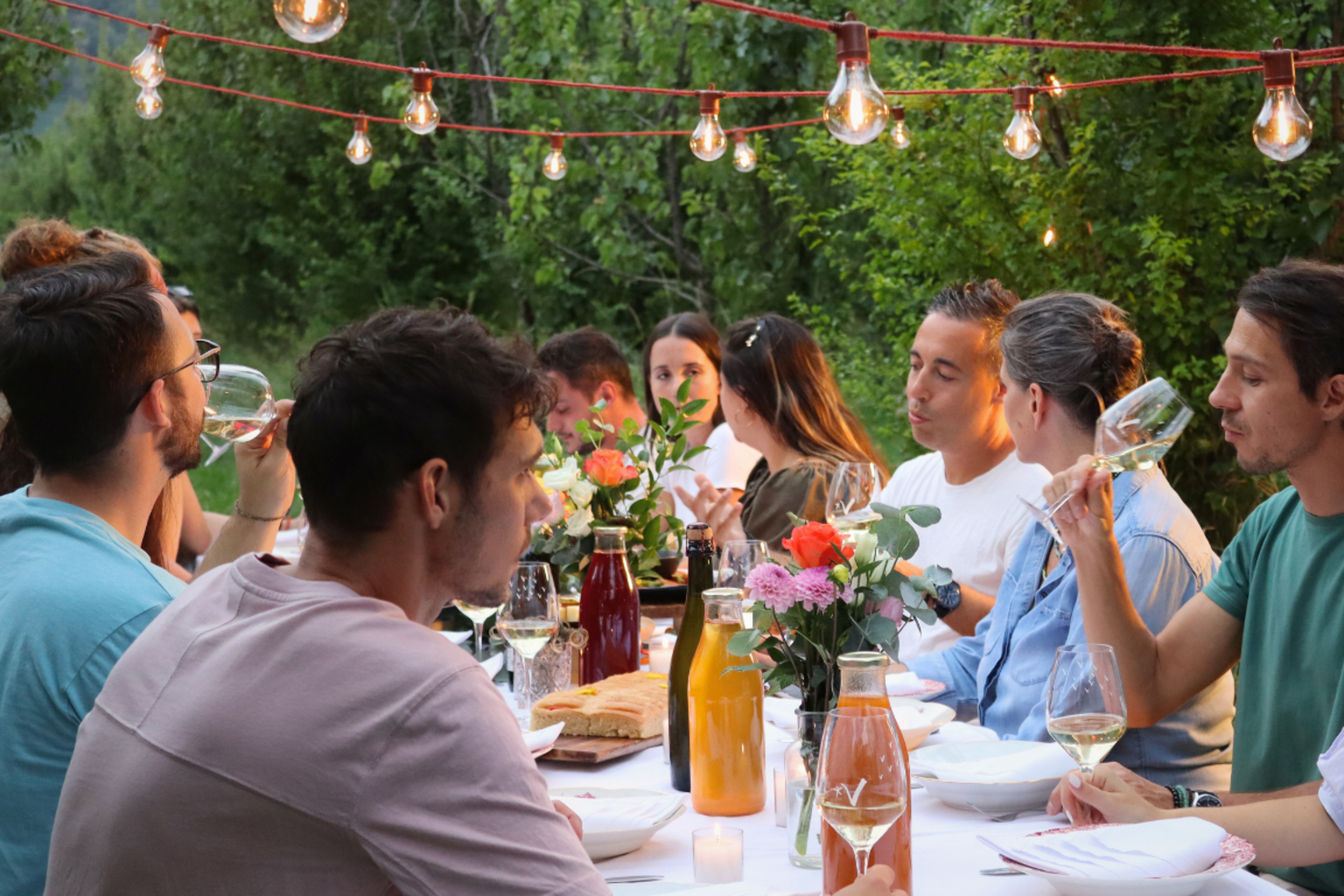 Eine Gruppe von Kollegen teilt ein Essen an einem Tisch im Freien im Wallis. 
