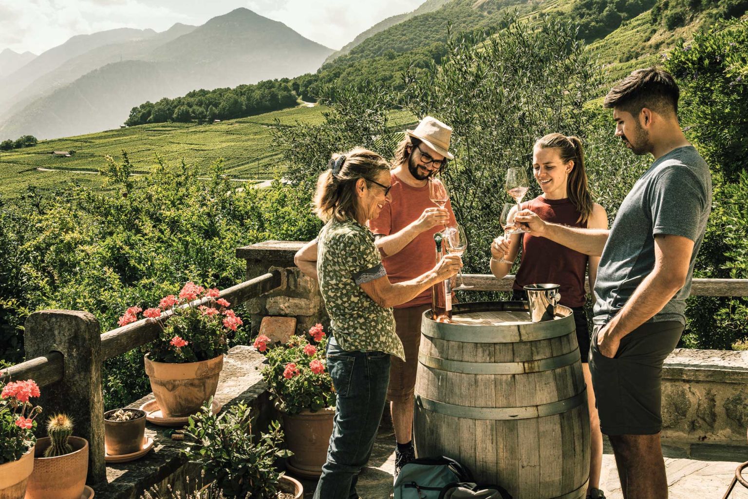 3 Erwachsene verkosten Wein mit dem Einkellerer in den Walliser Weinbergen. Fully, Wallis, Schweiz