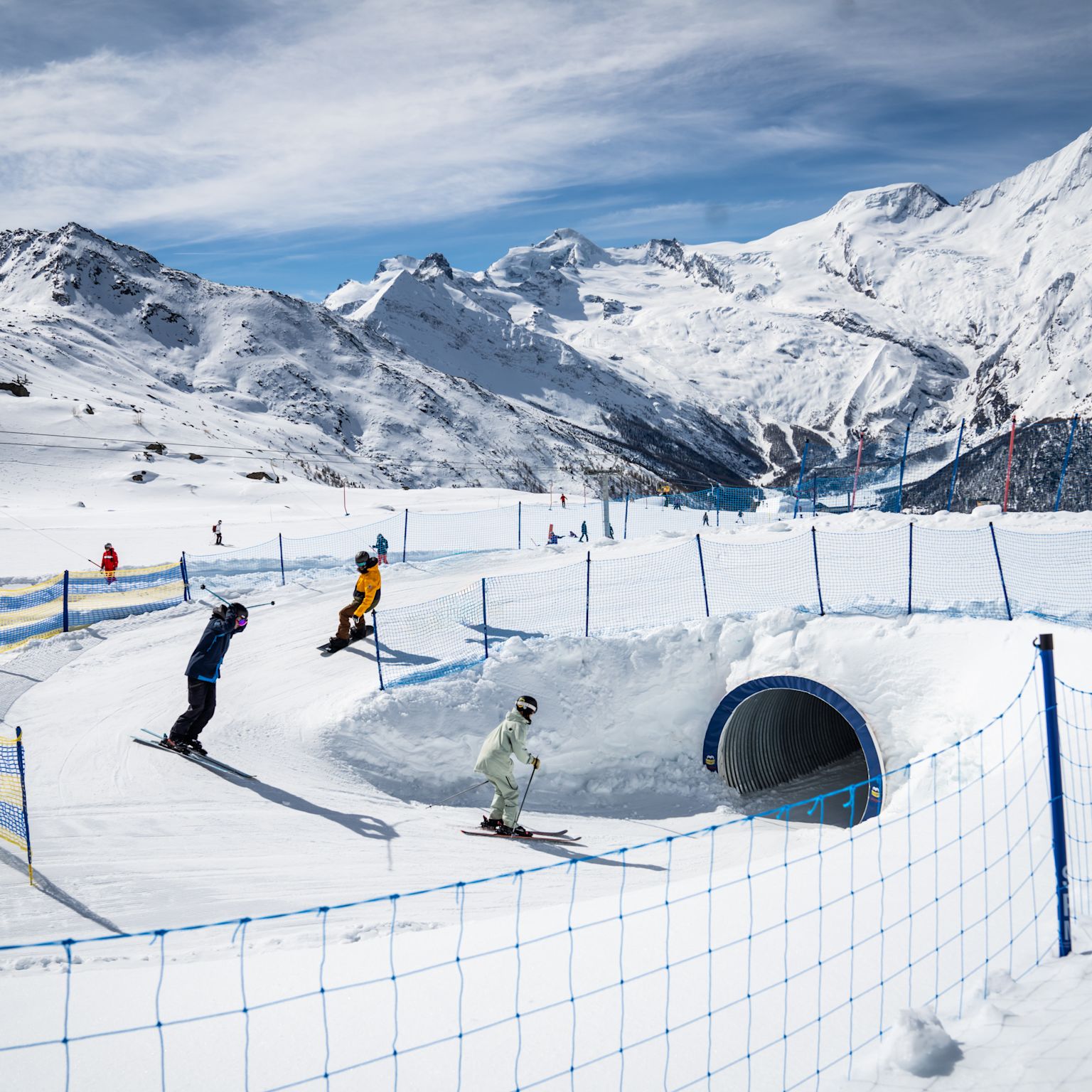 Skifahrende Kinder im Snowland Kreuzboden, Tunnel und verschneite Berglandschaft