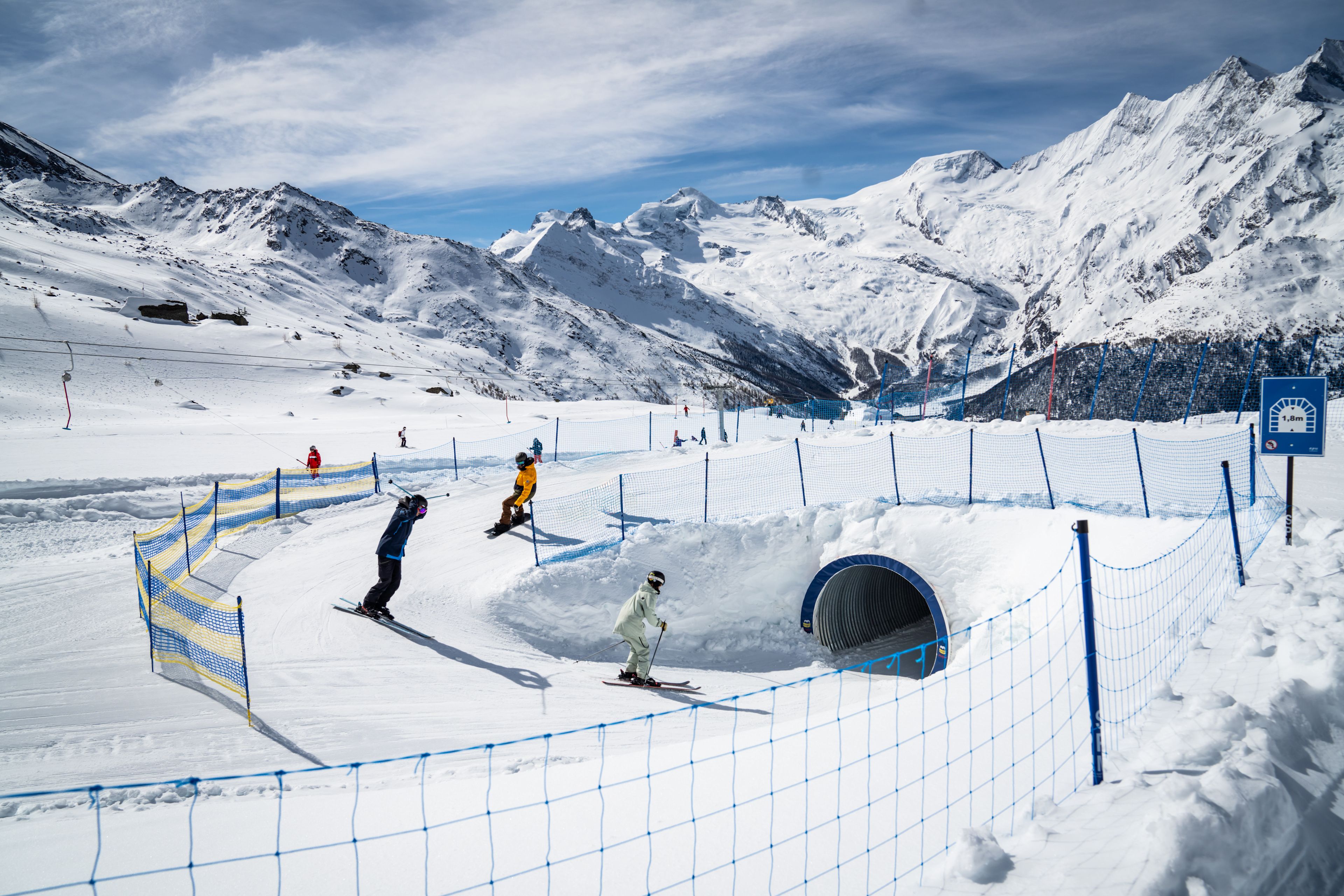 Skiing children in Snowland Kreuzboden, tunnel and snowy mountains
