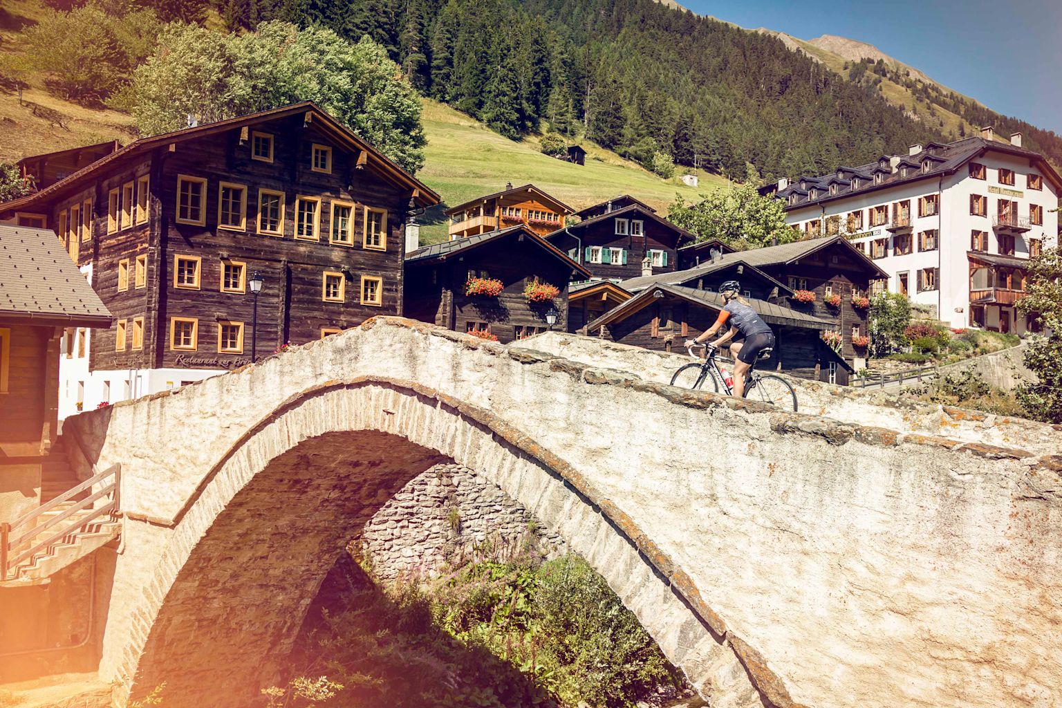Cycliste sur le pont de Binna à Binn. Valais. Suisse.