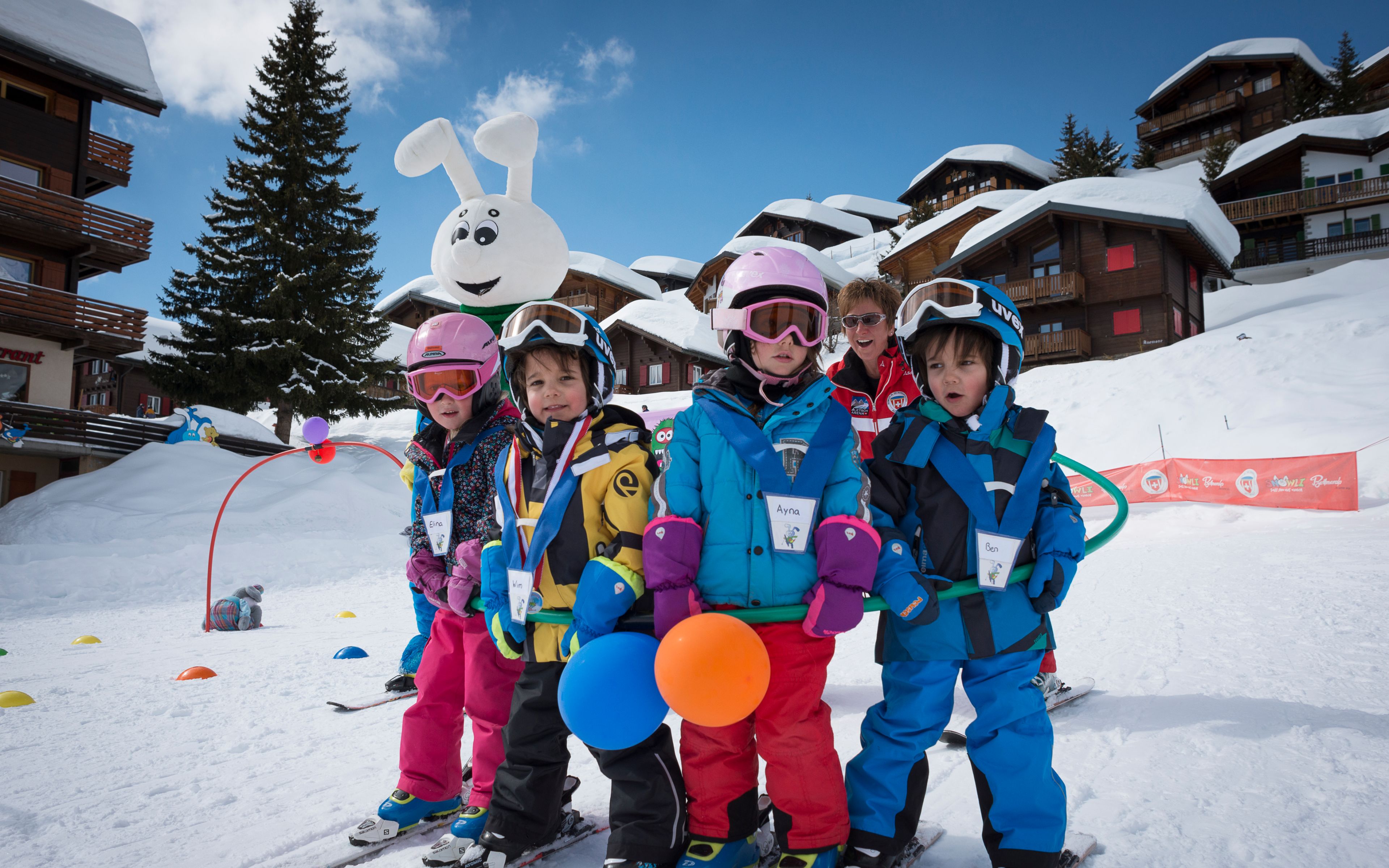 Photo de groupe des apprentis skieurs au jardin des neiges à Bettmeralp avec la mascotte