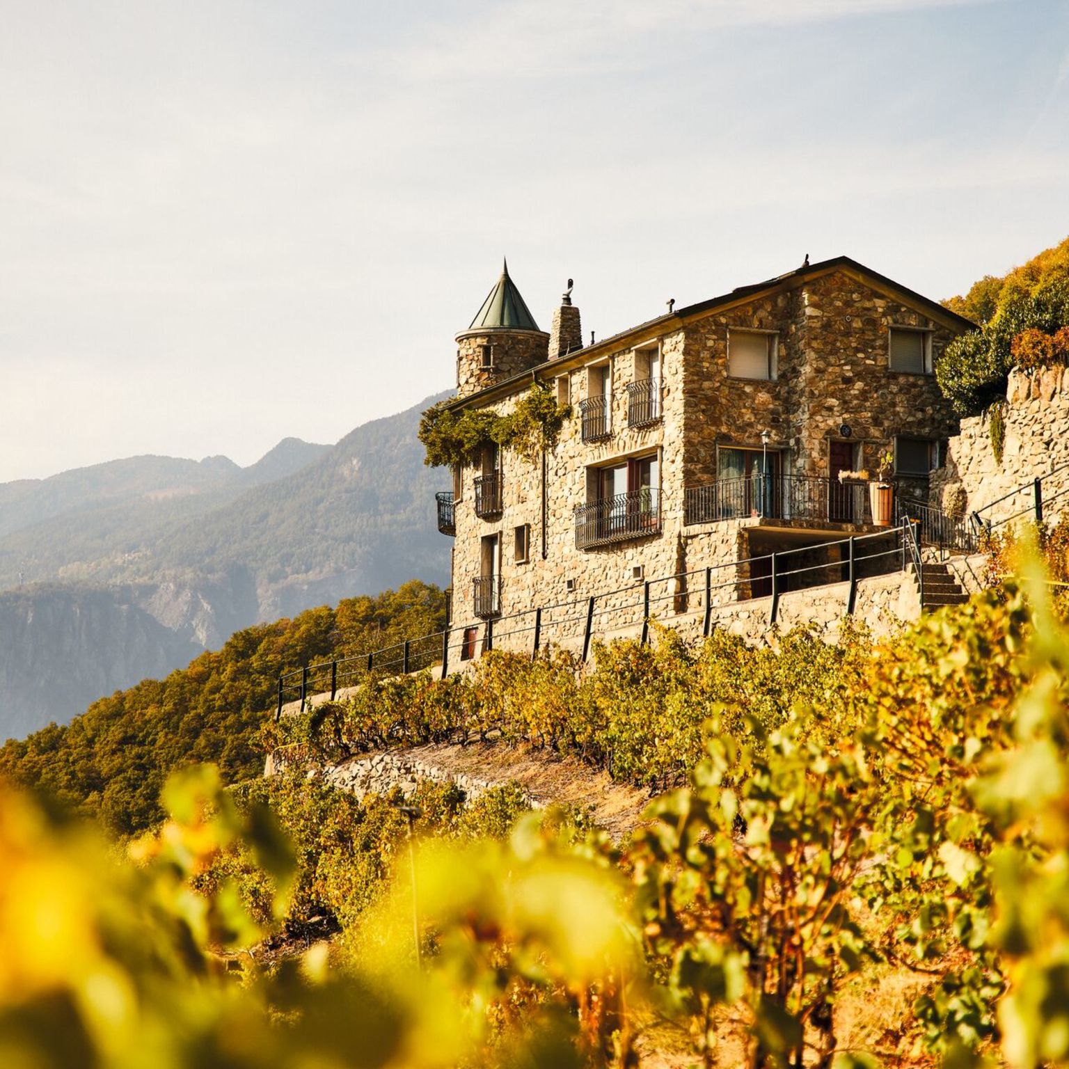 Ein Steinhaus unter blauem Himmel an einem Sommertag in den Walliser Weinbergen