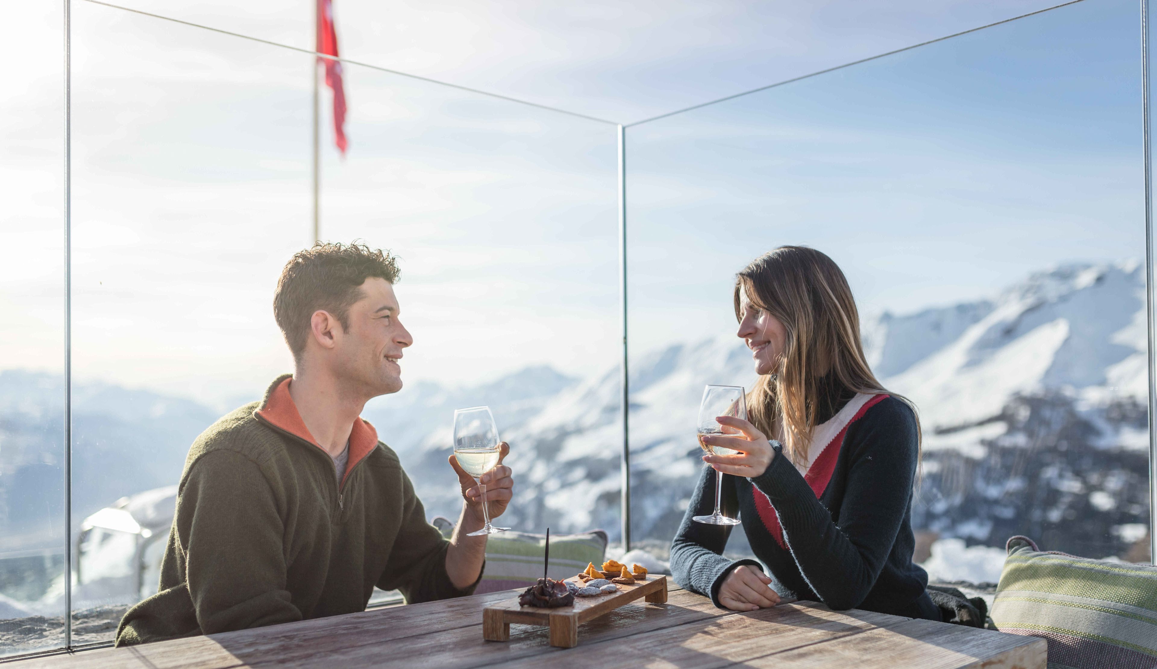 Deux personnes prennent l'apéro après une journée de ski sur la terrasse. Valais, Suisse