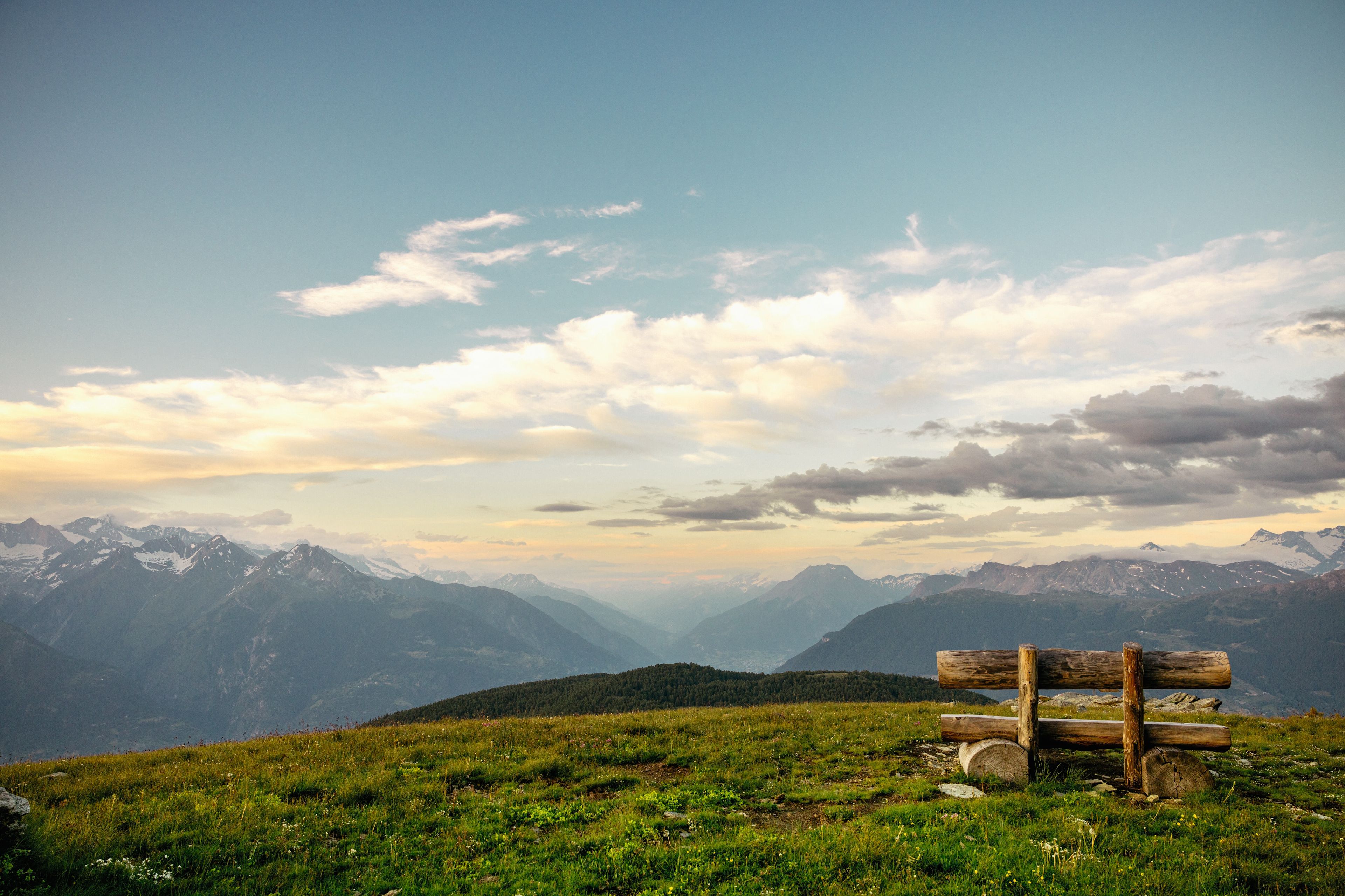 Wooden bench on the Moosalp with a wide Alpine panorama at sunset, Valais, Switzerland