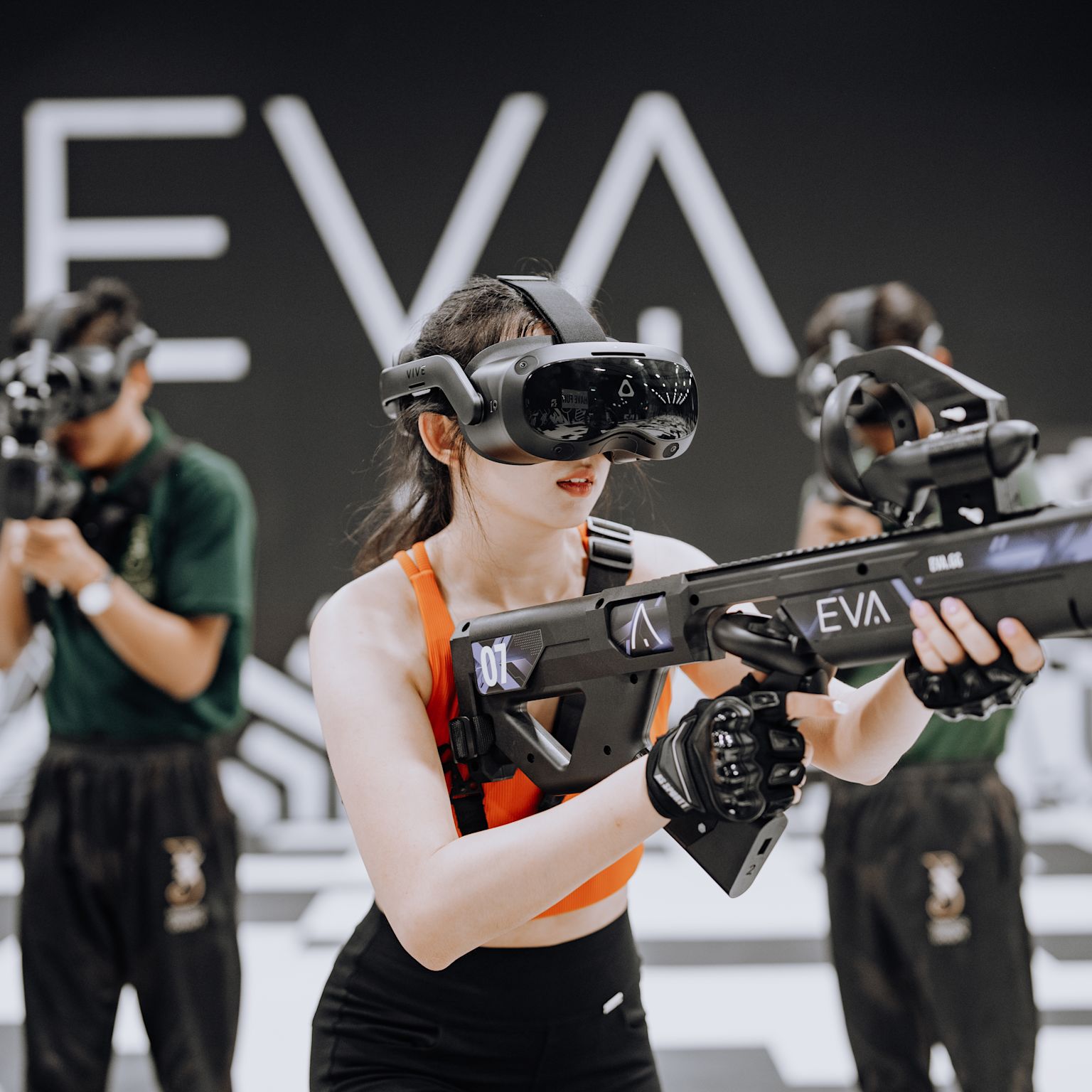 Three players wearing VR headsets and holding futuristic guns while playing in an EVA eSports arena, Martigny, Valais, Switzerland