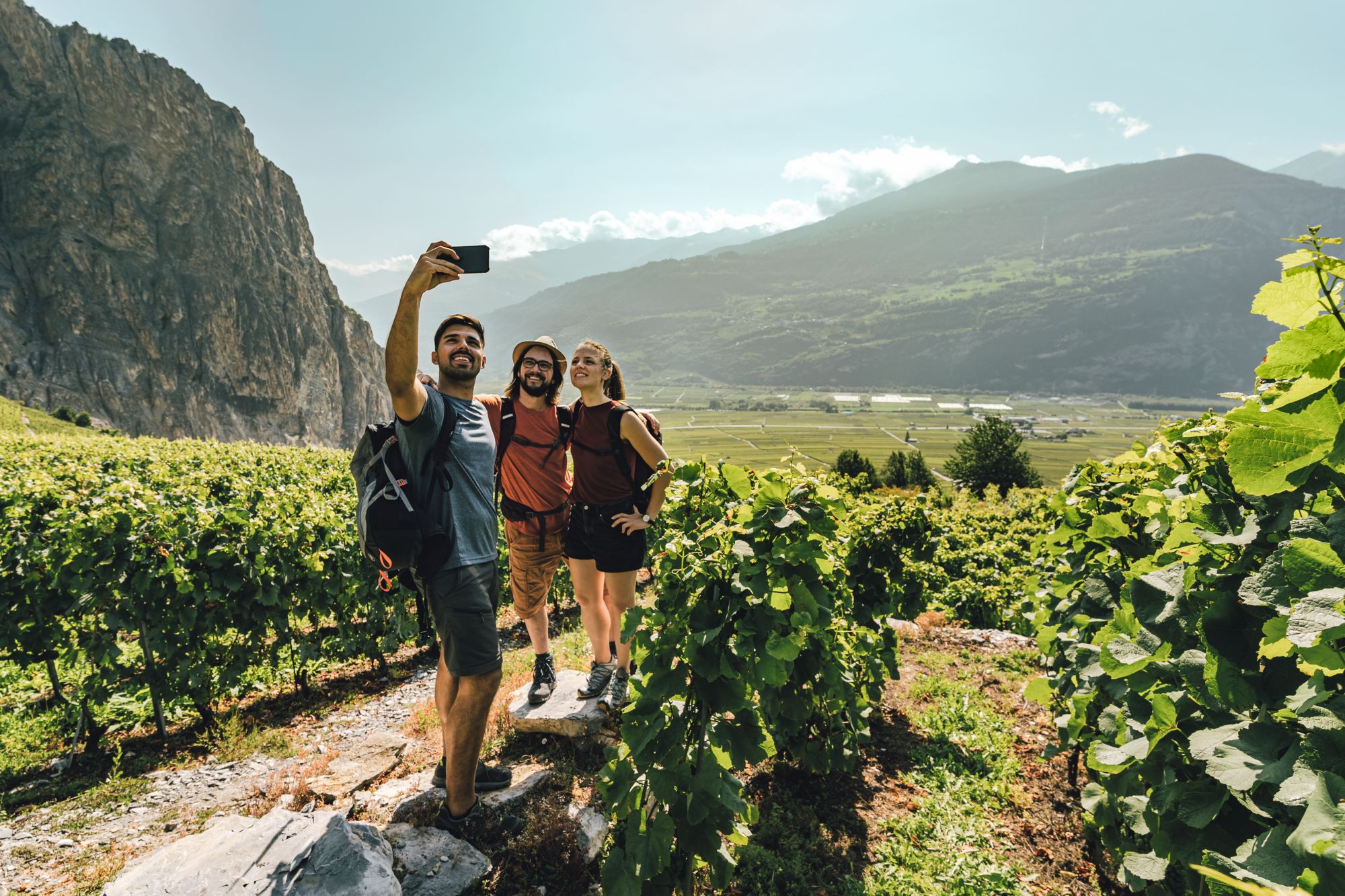 3 Erwachsene machen ein Foto Selfie in den Weinbergen von Chamoson, Wallis, Schweiz